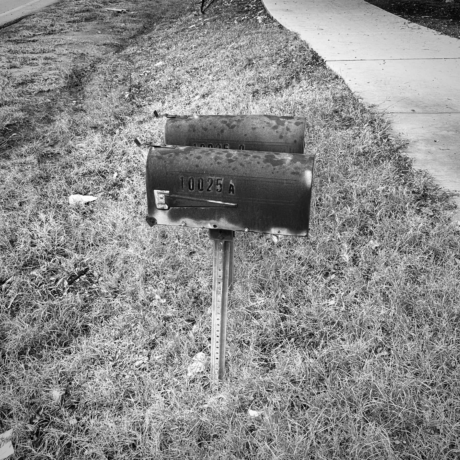 Old rusty mailboxes on the side of the road.