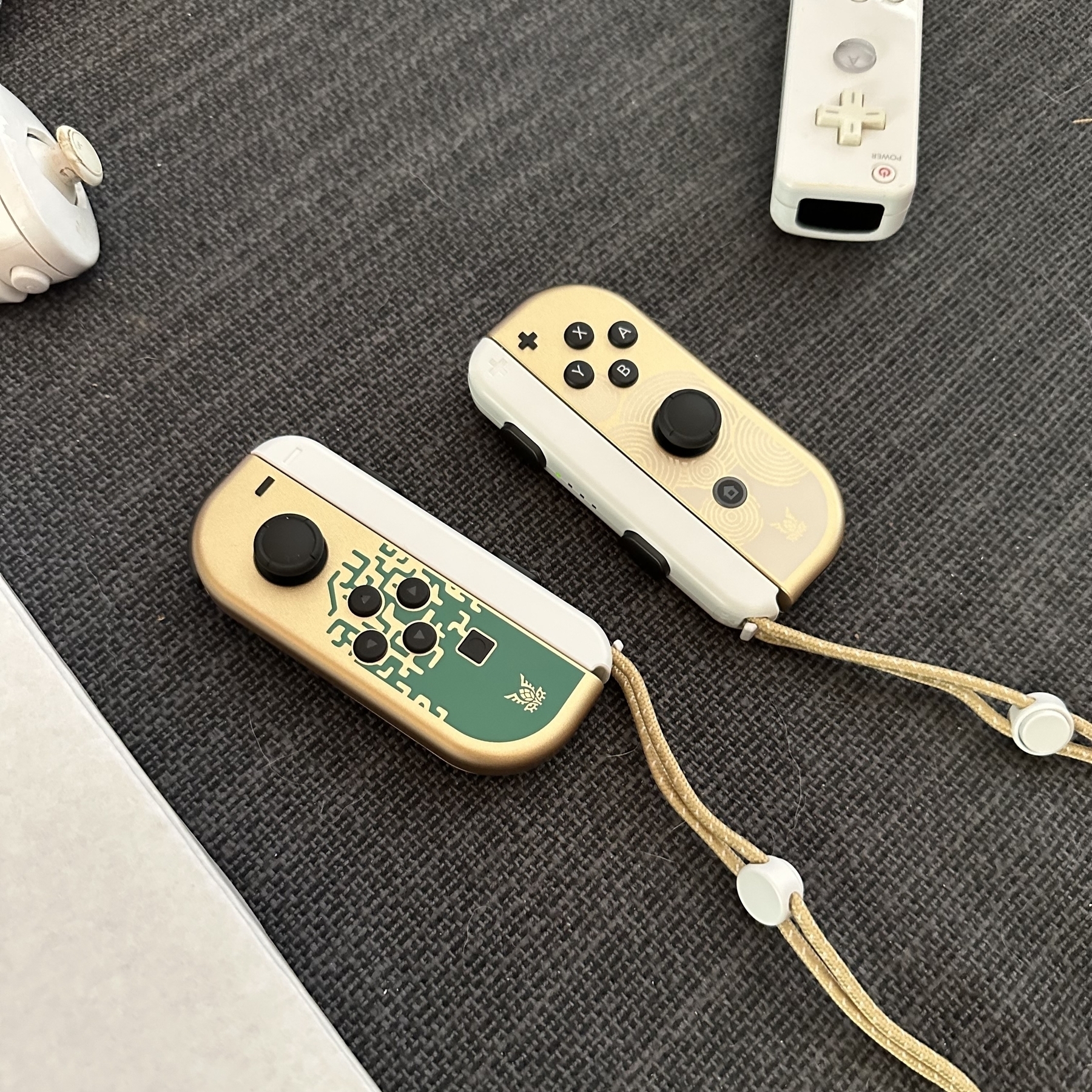 Switch controllers with Zelda-themed pattern and old Wii controller.