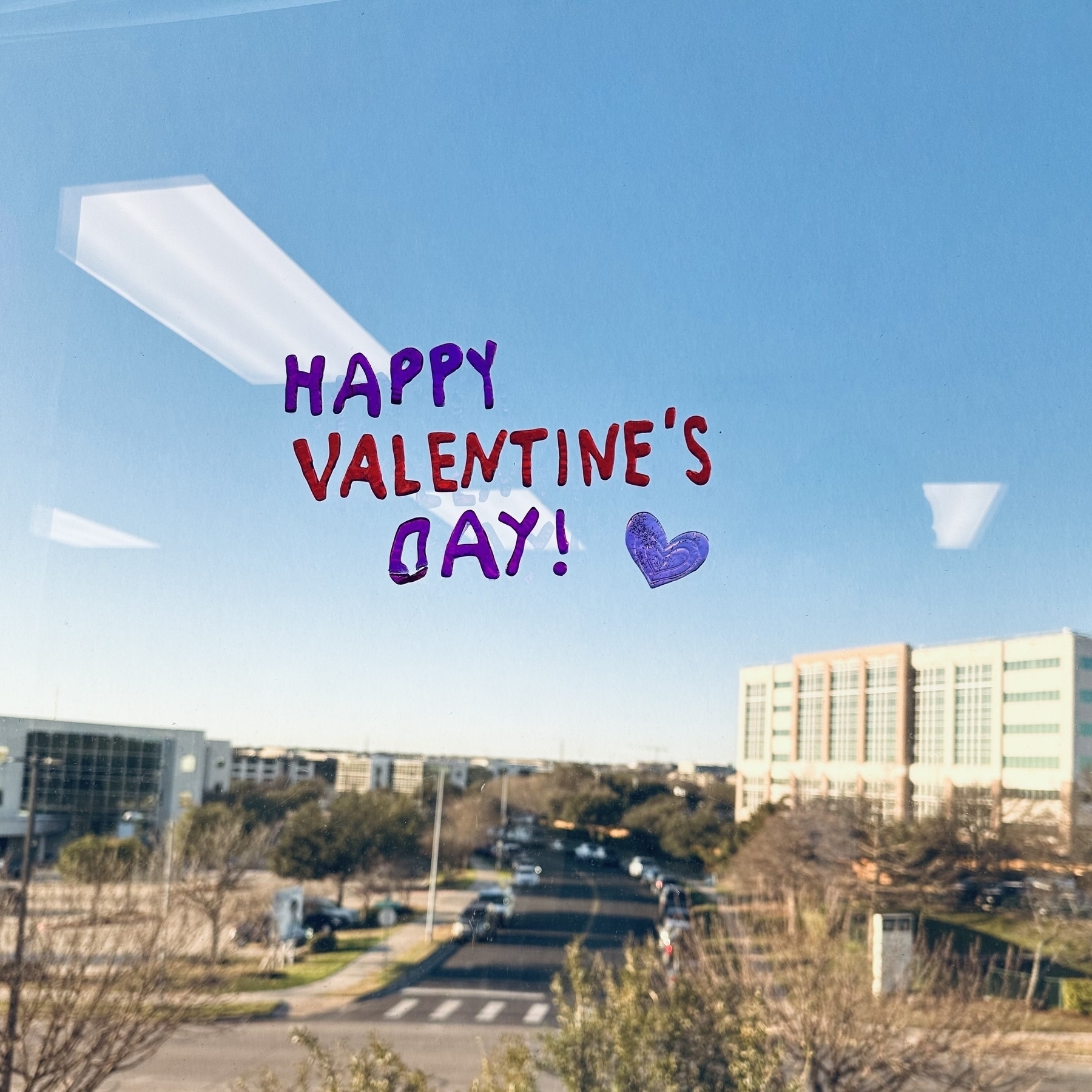 Happy Valentine’s Day with heart drawn on window.