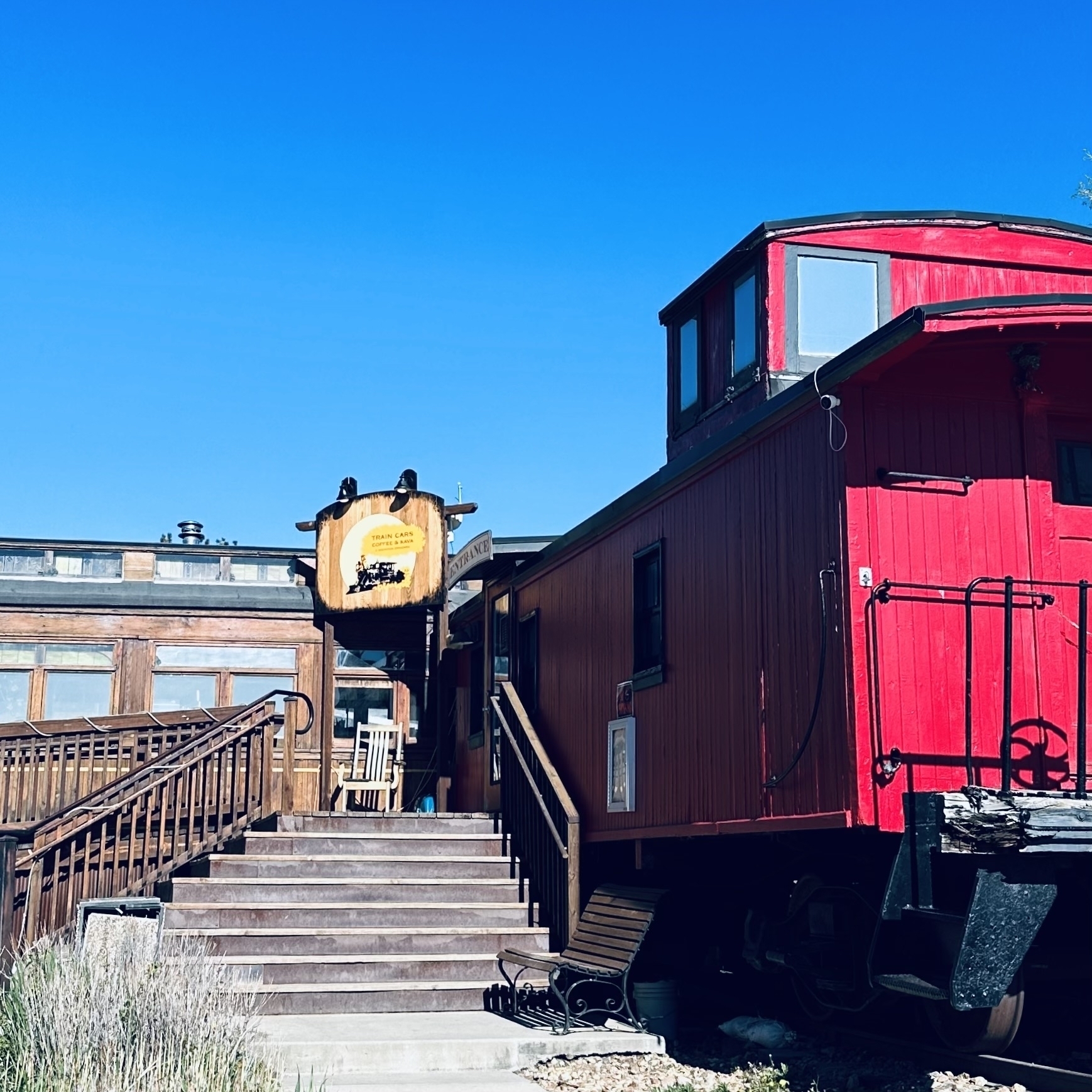 Caboose and train cars with stairs leading up to door.