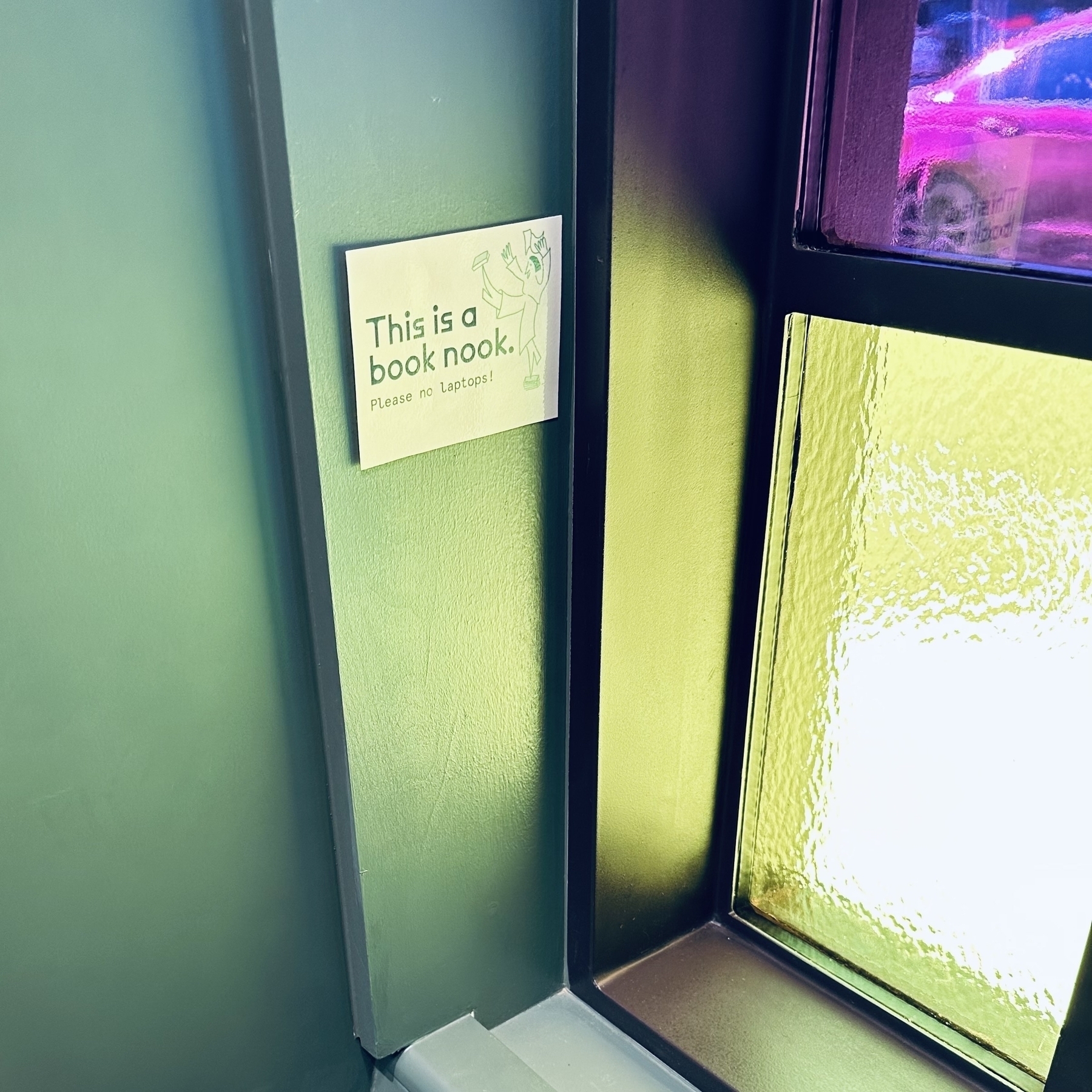 Seat by the window with a sign.