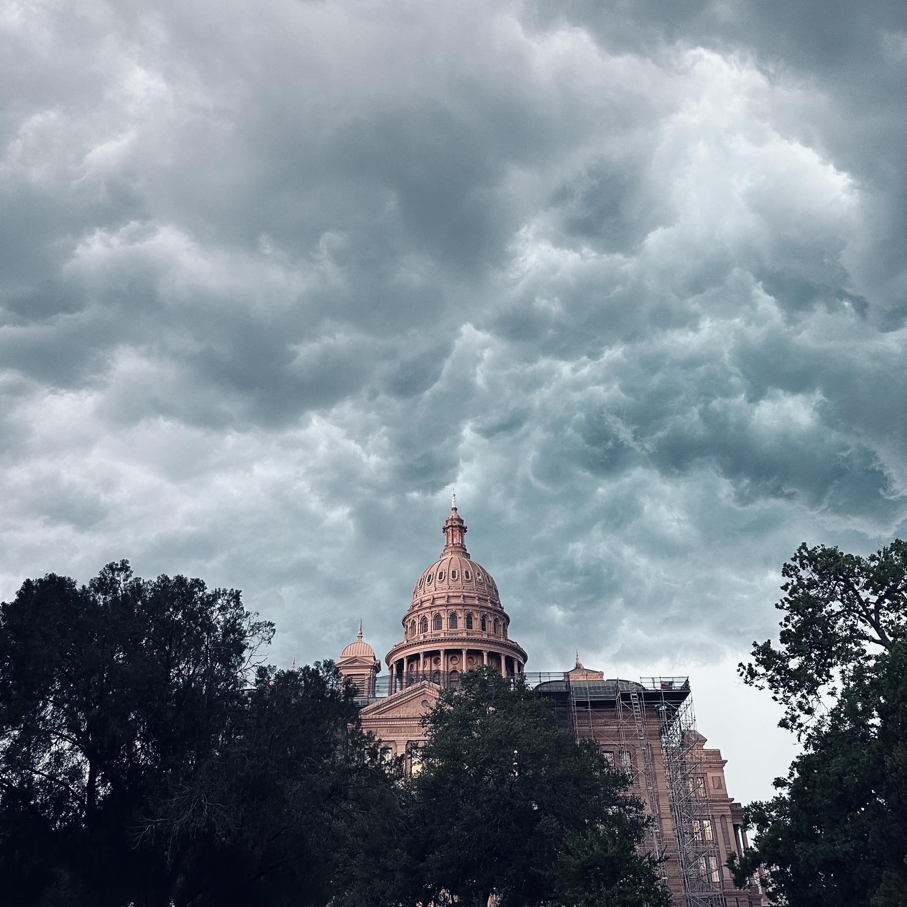 Texas Capitol building with gray clouds.