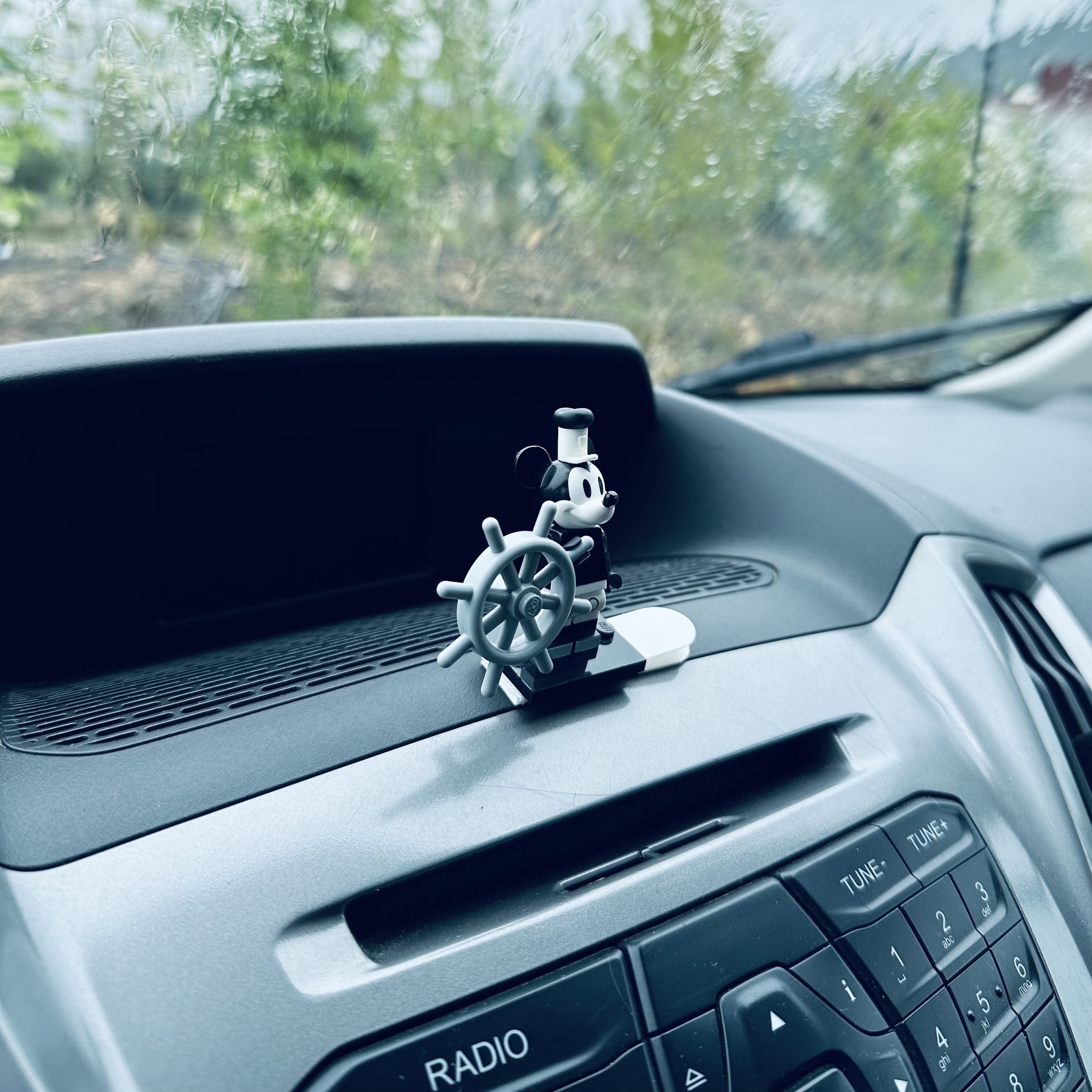 LEGO Mickey Mouse attached to van dashboard.