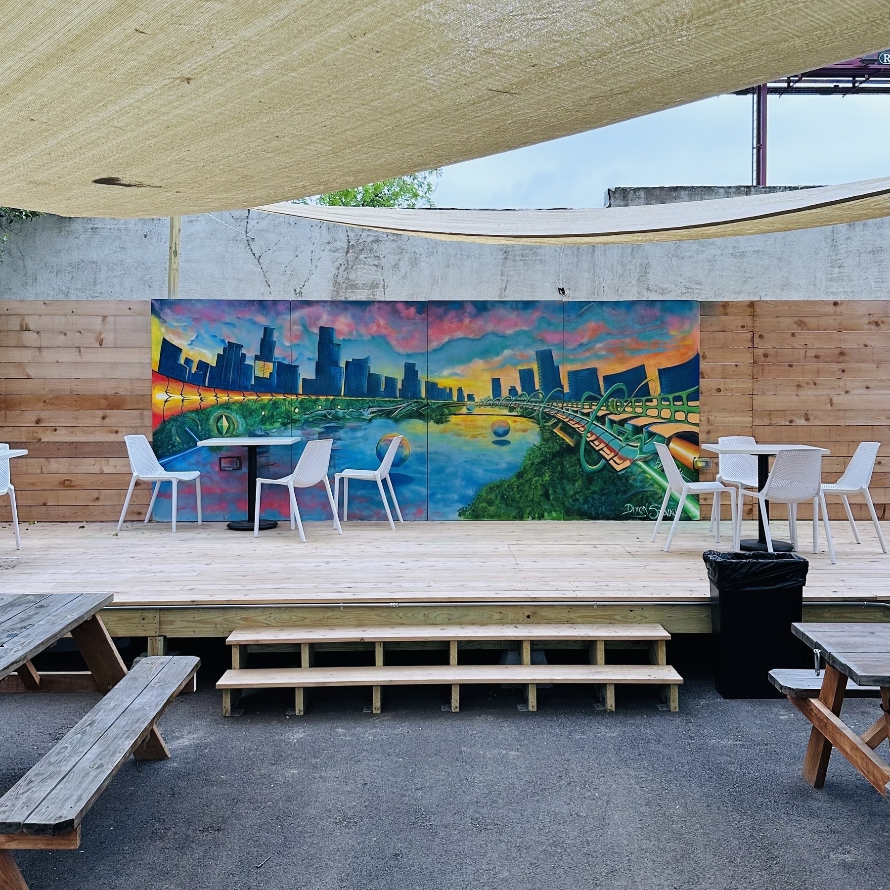 Photo of painting of Austin with picnic tables at coffee shop.