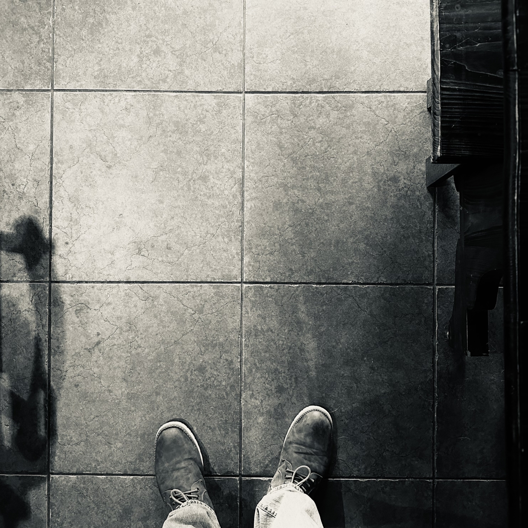 Looking down at the tile floor with shoes visible.