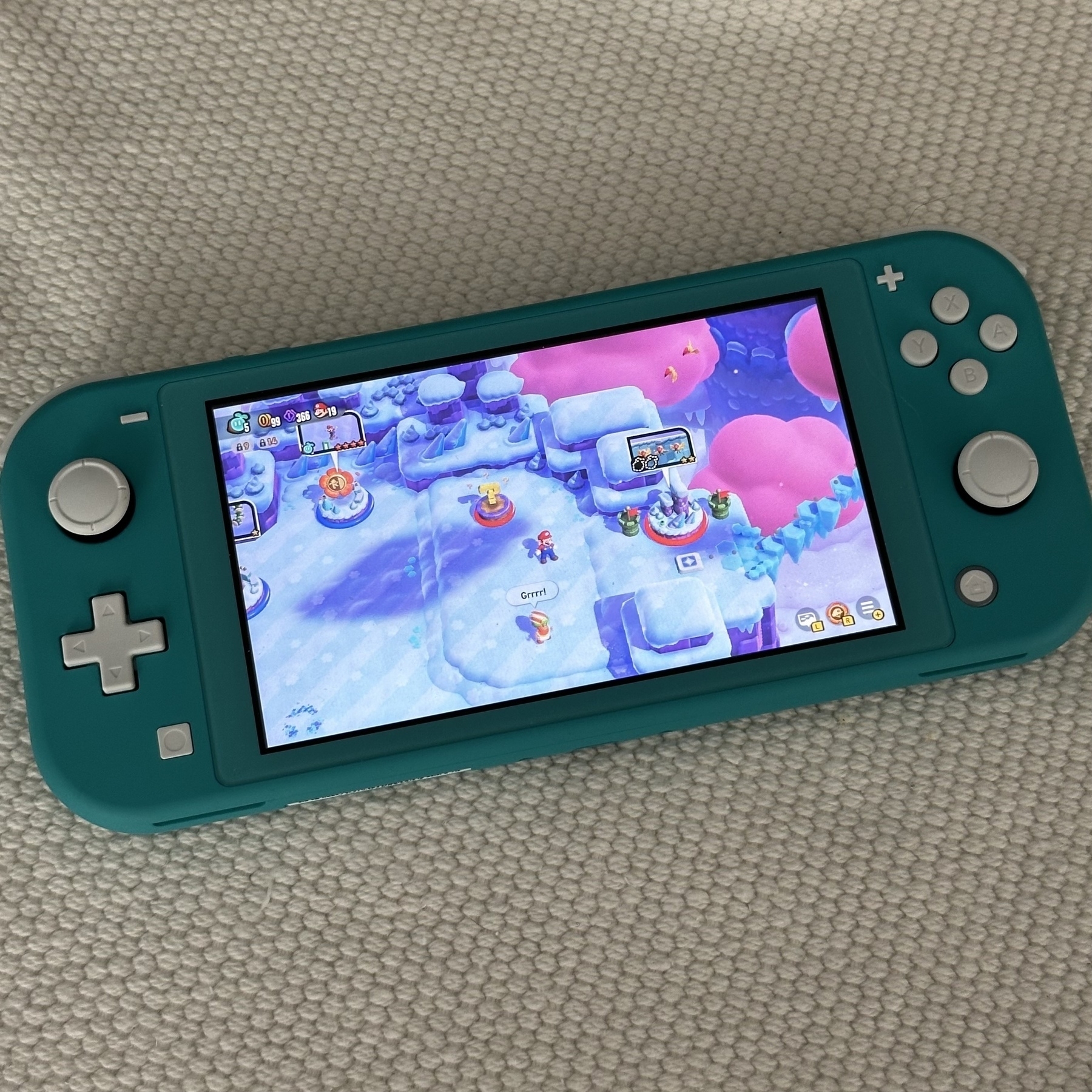 Turquoise Switch Lite playing Super Mario Bros. Wonder. 