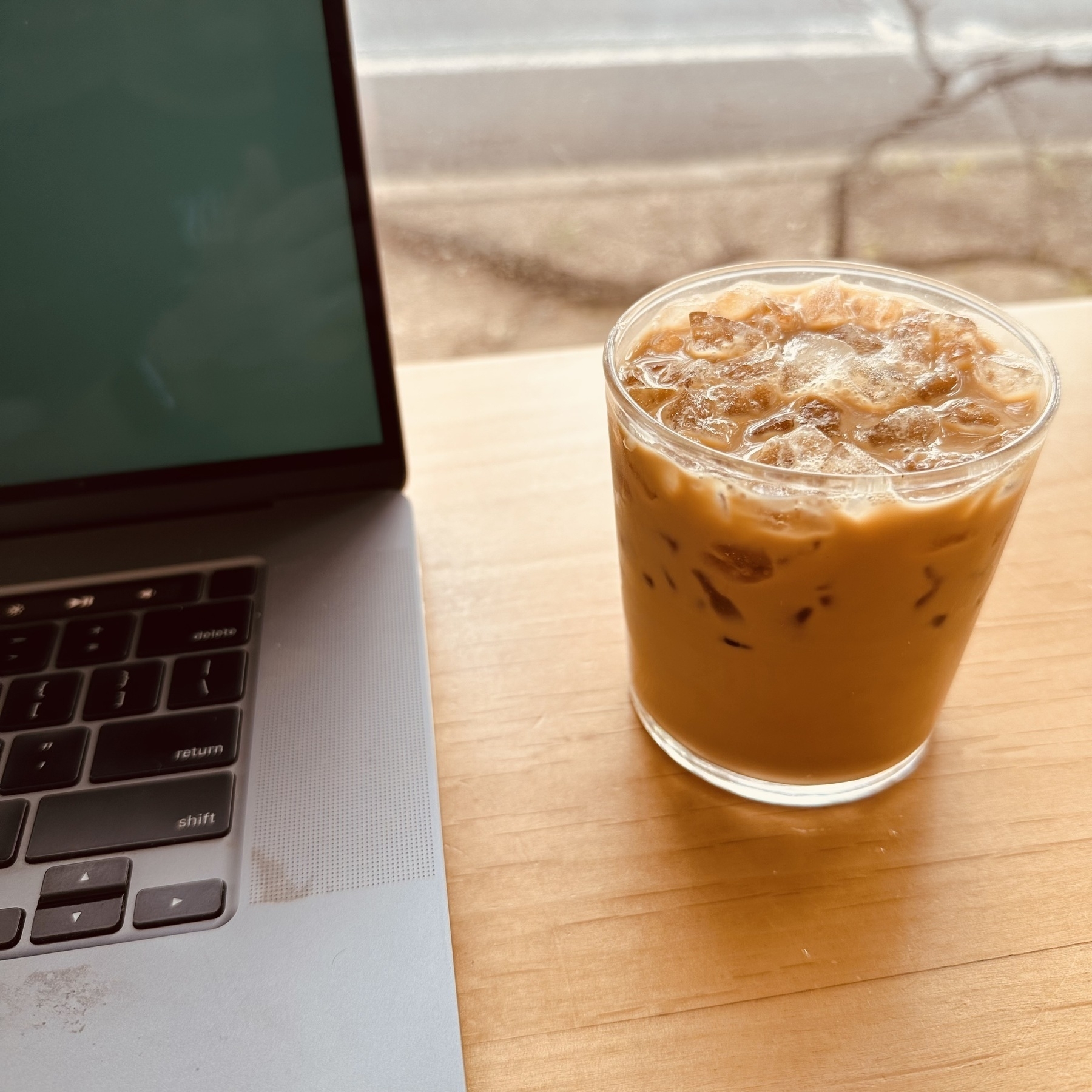 Photo of my laptop and iced coffee, Guadalupe Street in background.