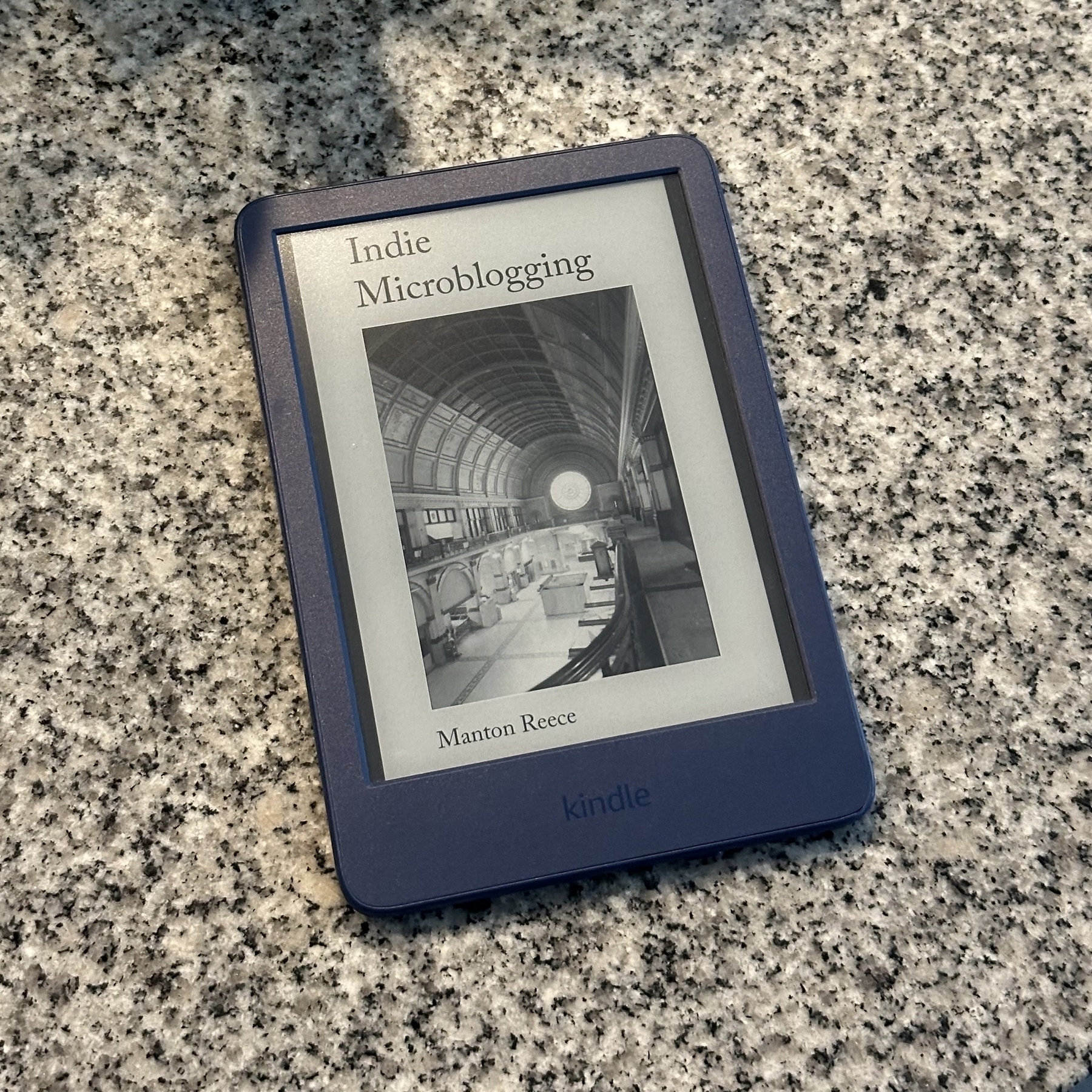 Kindle with book cover of Indie Microblogging shown.