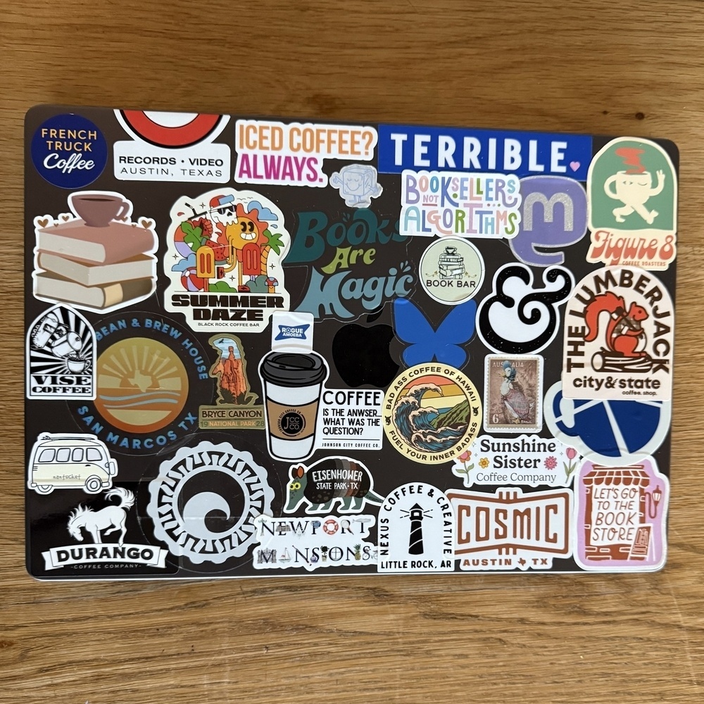 MacBook Pro with stickers all over the cover, from coffee shops, parks, and other travel.