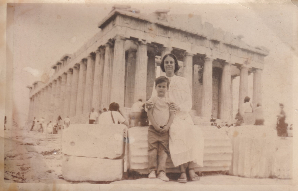 Me and my mom pose in front of the ancient Parthenon temple on the Acropolis, with several other visitors in the background.