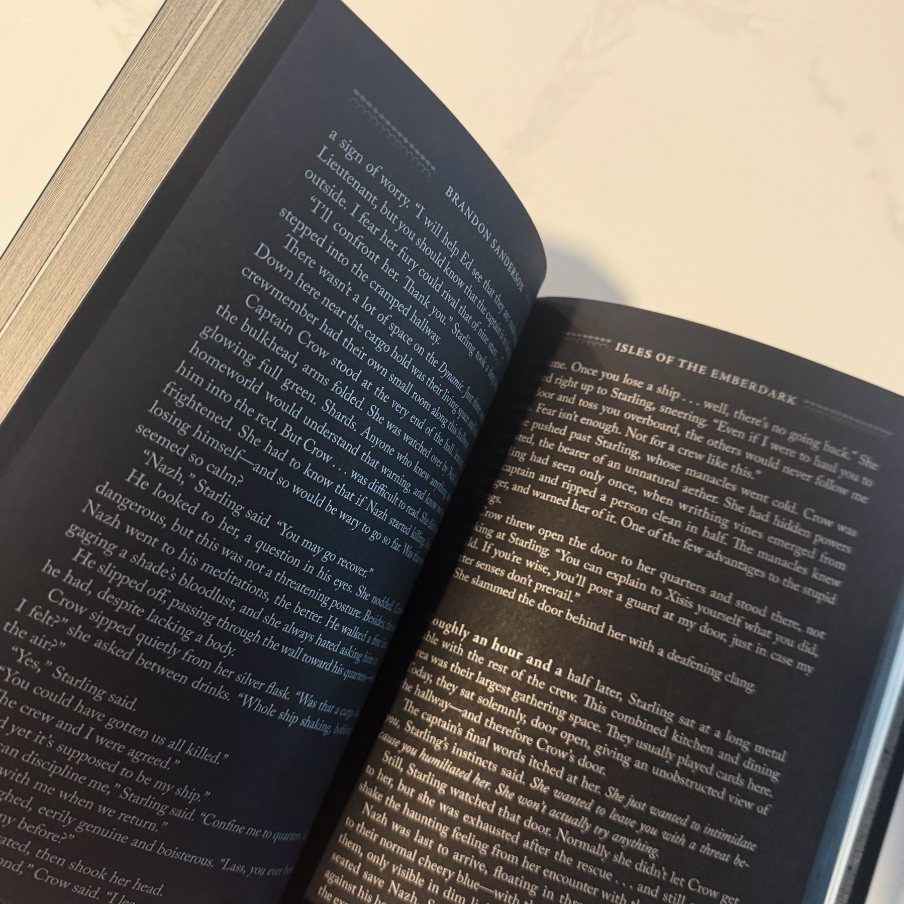 A book open showing the edges of some white pages and the open facing pages that are black.