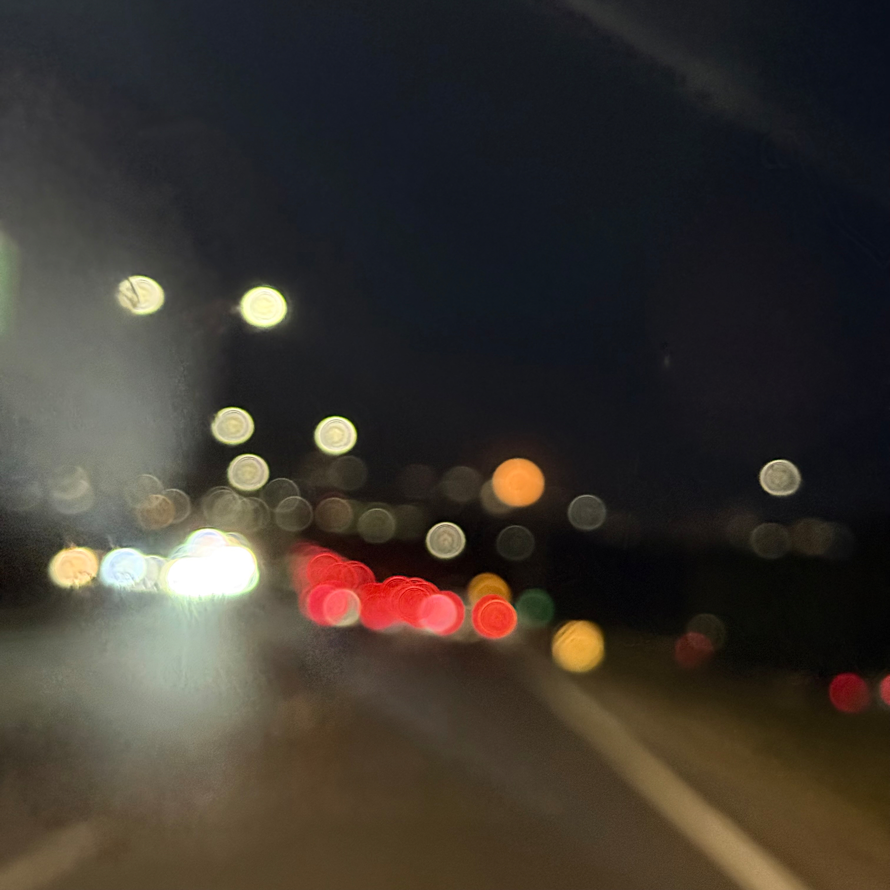 Blurred lights and vague shapes create the impression of a nighttime scene with bokeh effects.