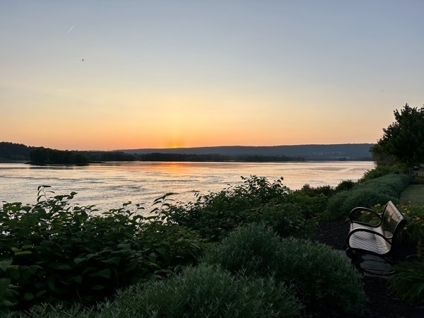 Sunset over the Susquehanna River in Harrisburg Pennsylvania USA. A bench sits off to the left of the image, perfect spot to enjoy the scenary. 