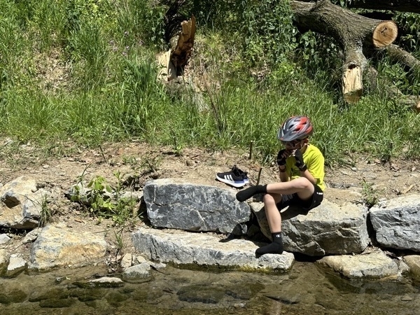 Boy sitting by a creek