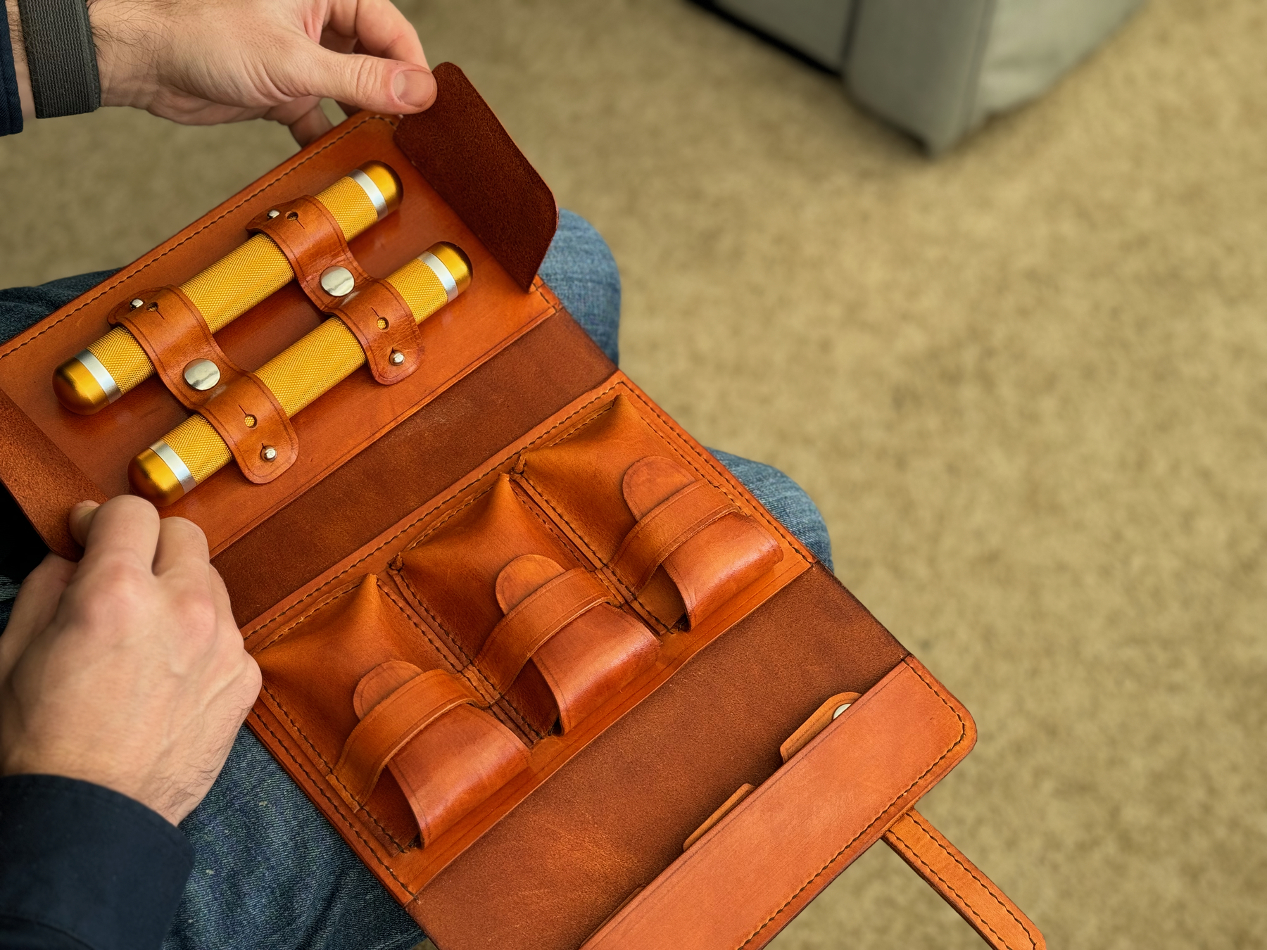 custom leather cigar case shown open with cigar tubes in place on the very left of the case