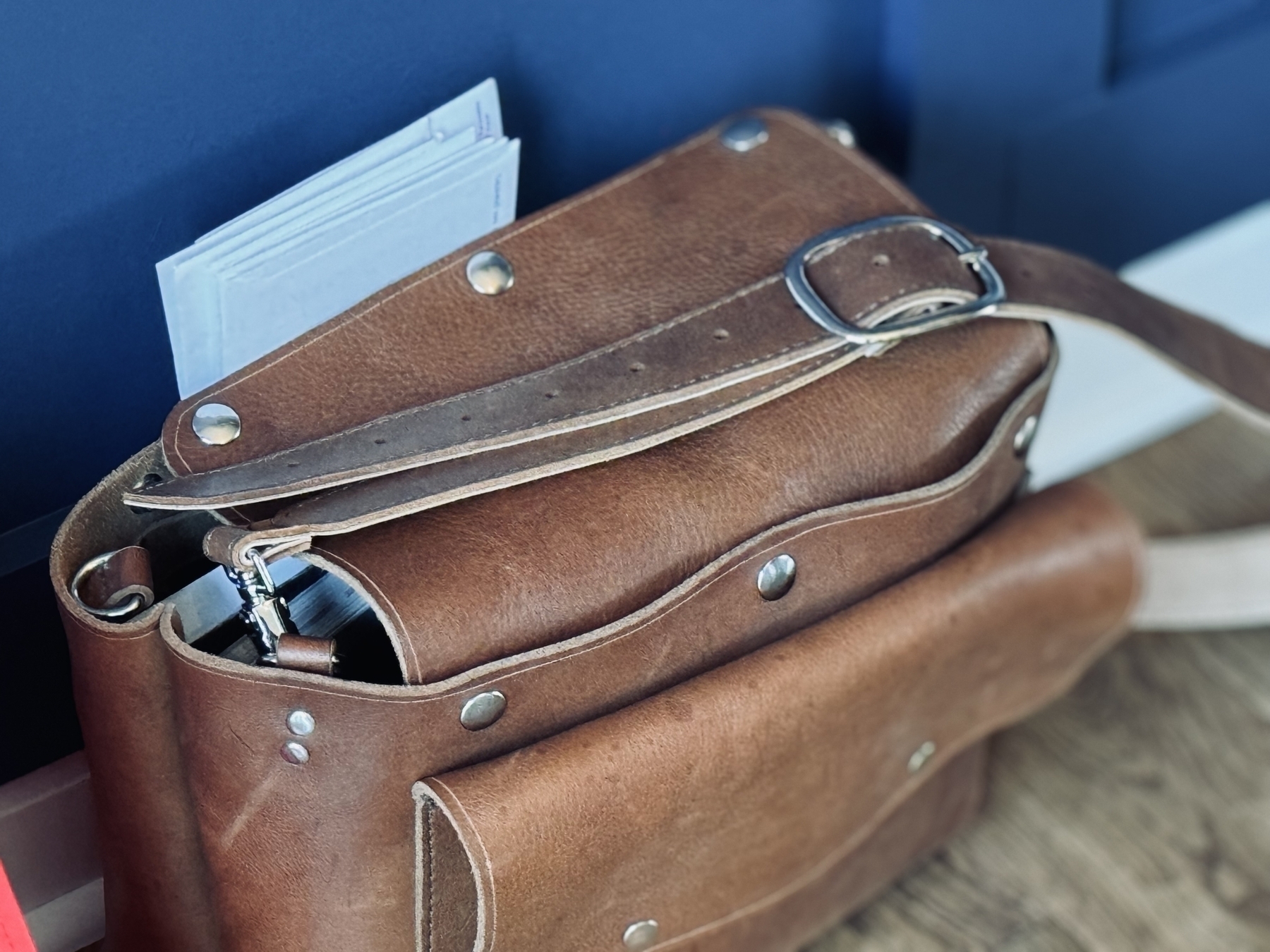 A brown leather bag is partially open, revealing papers peeking out from inside.