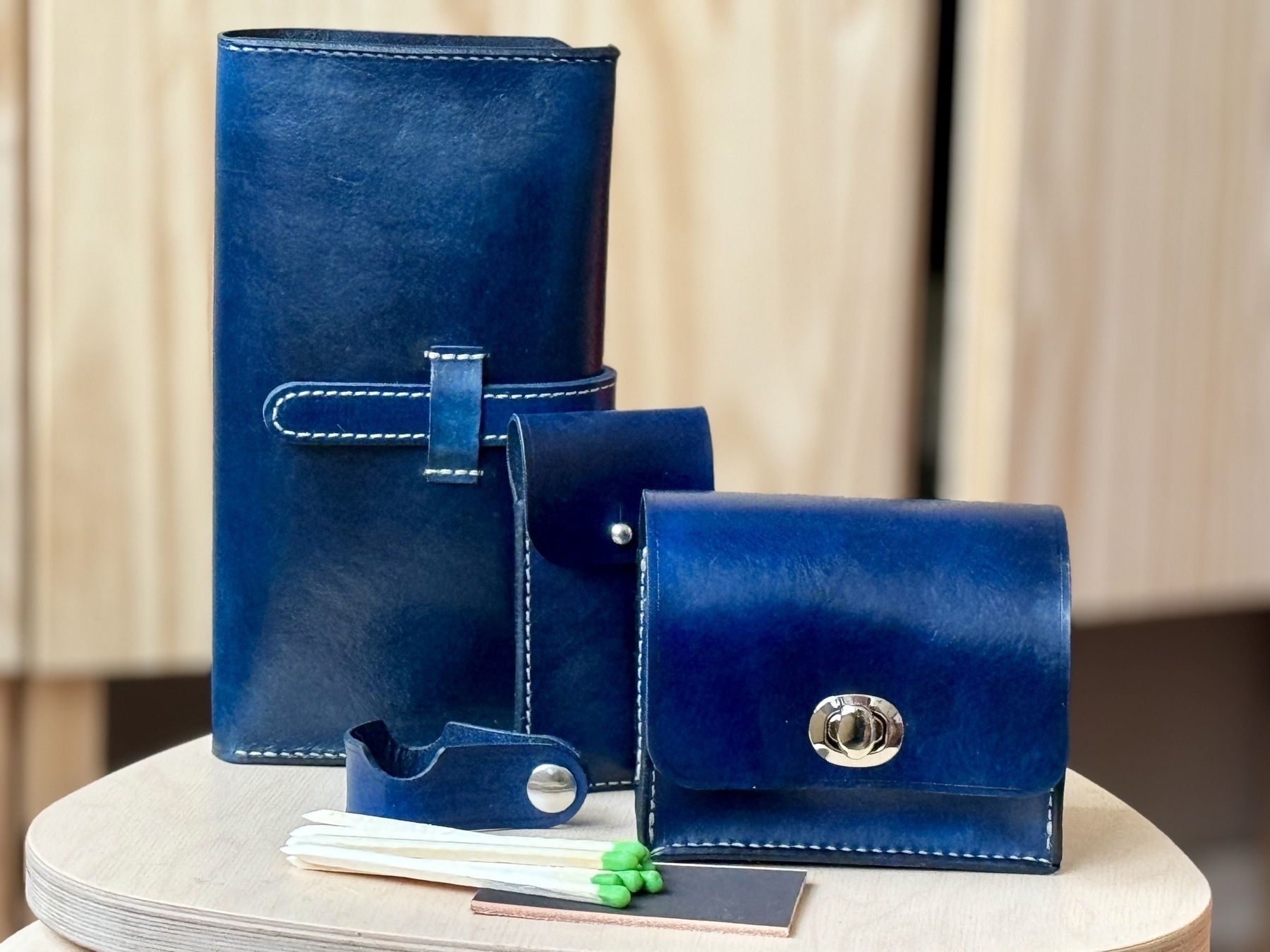 Leather cigar gift set in hand dyed royal blue. A large cigar case for holding cigars with a Boveda humidor bag, lighter, and cutter, a small leather pouch for holding cigar matches, a snap up leather cigar stand, and a leather cigar box with hand cut hand carved cigar matches. 