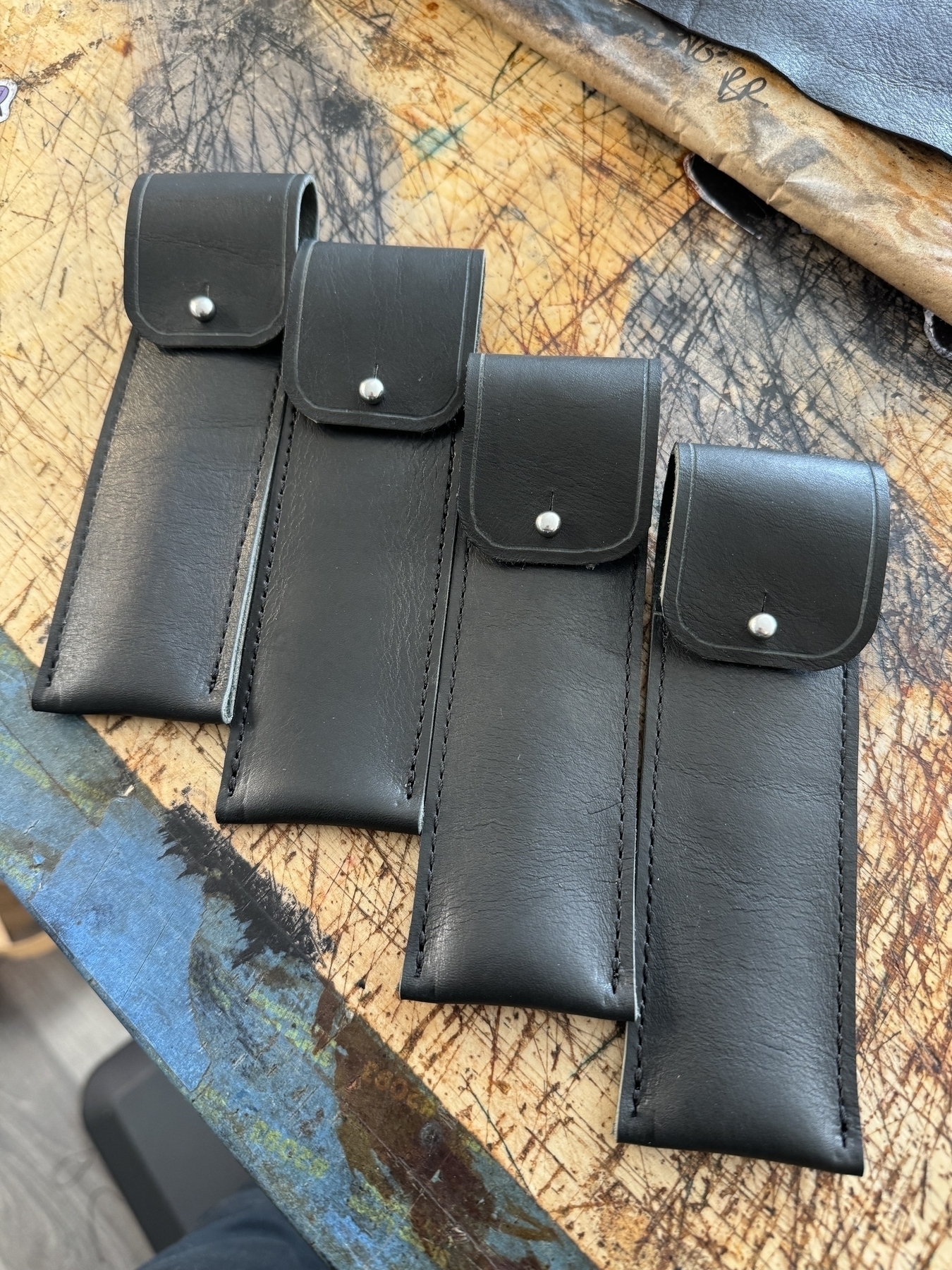 Four black leather fountain pen cases. 