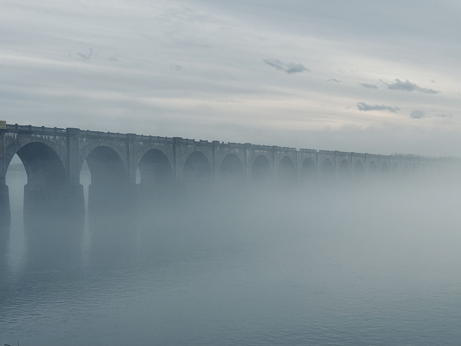 Fog over the Susquehanna river in Harrisburg Pennsylvania. A train bridge disappearing into the fog. 
