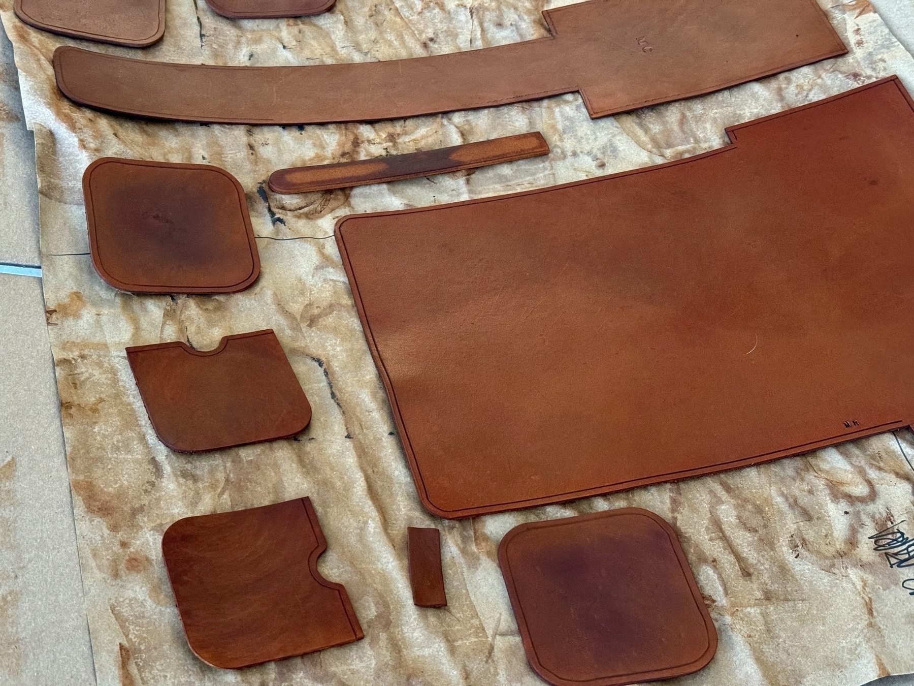 Individual pieces of leather with wet leather dye, brown in appearance. 