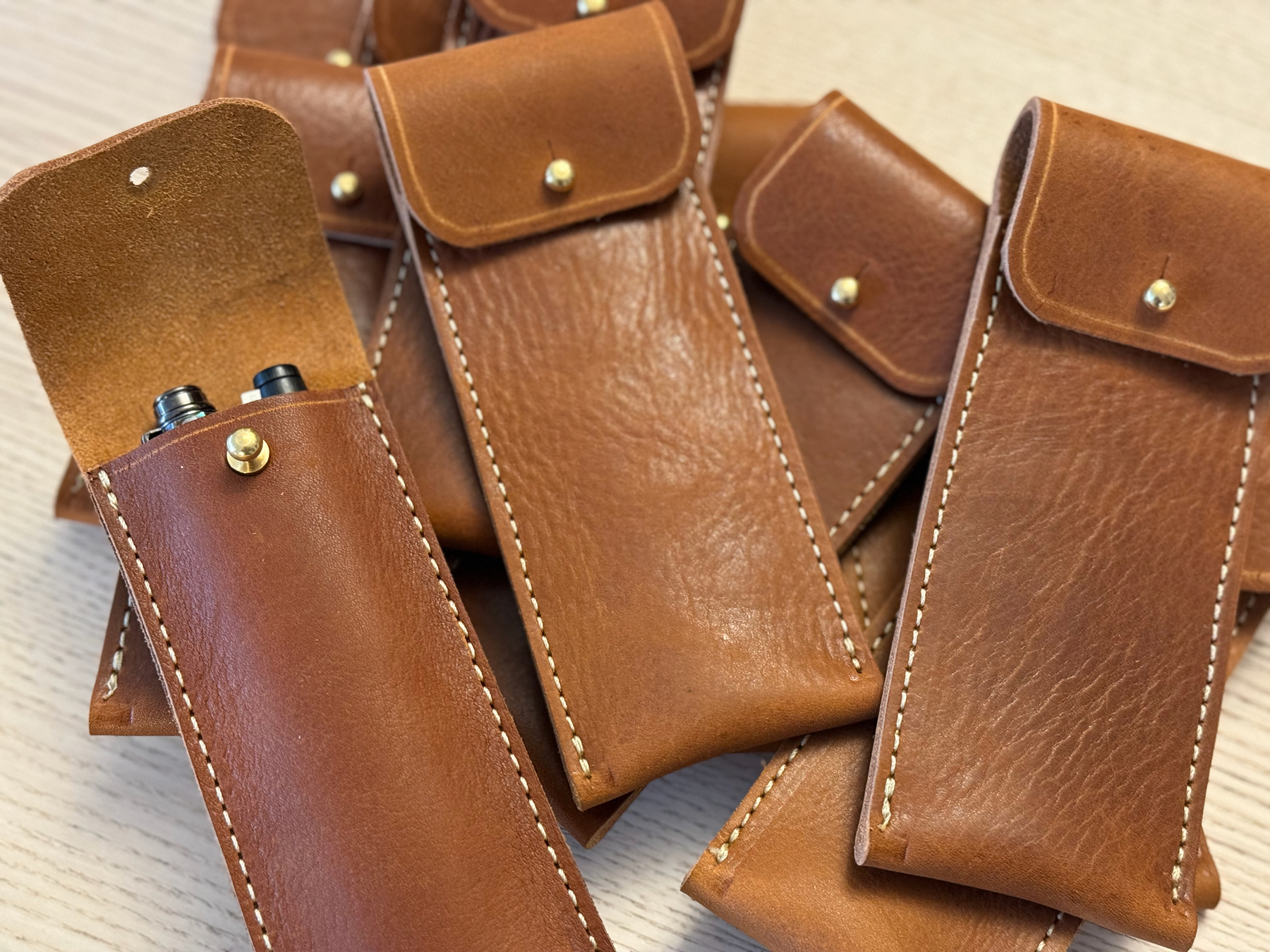 Pile of tan leather fountain pen cases