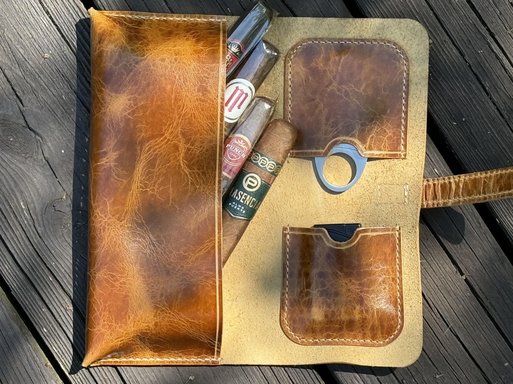 limited edition leather cigar case from A. M. Aiken - shown open with 4 cigars, lighter, and cutter.