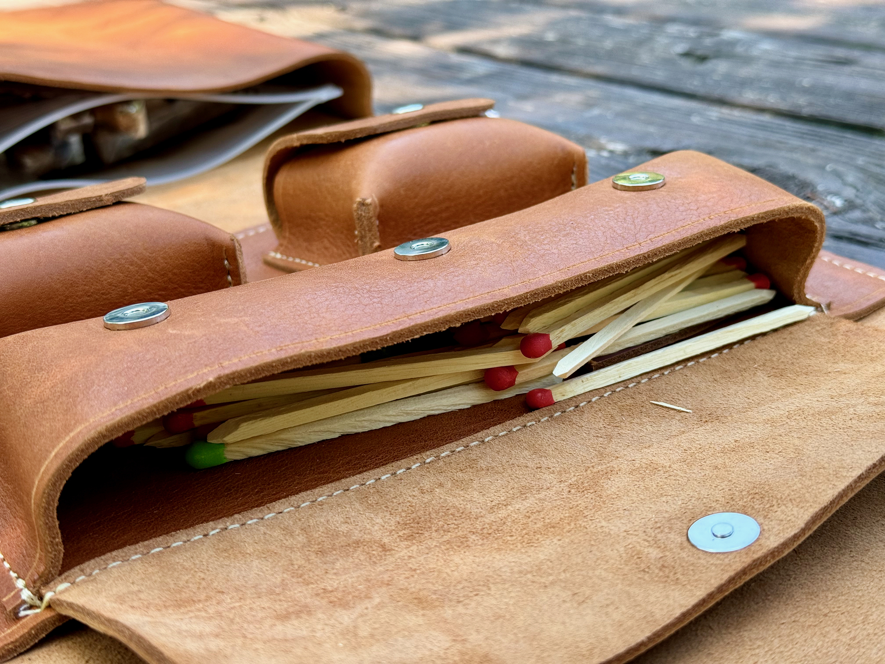 A leather cigar case contains a variety of premium cigar matches.