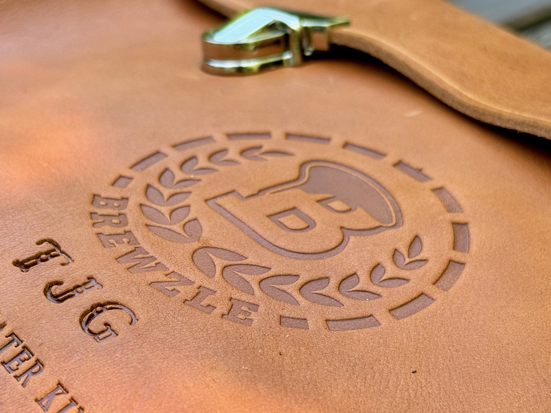 A close-up view shows a leather cigar case embossed with the logo 