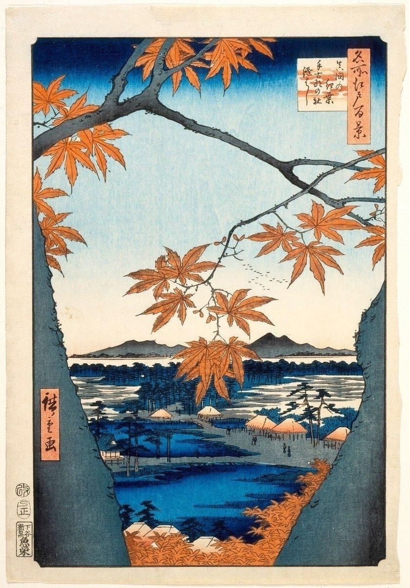 Japanese woodblock print depicting a serene landscape framed by tree branches with orange maple leaves. The background features a tranquil river with small boats and distant hills under a clear blue sky. Several huts and trees are visible along the riverbanks, with a few people walking along a pathway. Vivid colors and intricate details add to the scene's beauty.