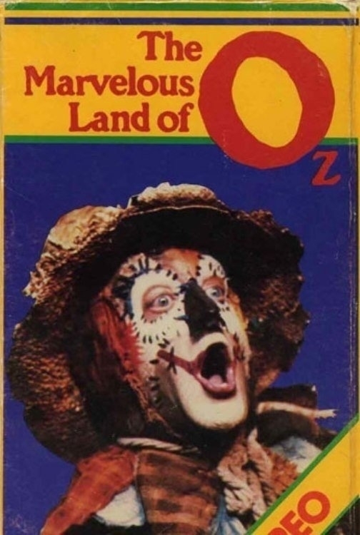 Cover of "The Marvelous Land of Oz" video, featuring a character dressed as a scarecrow with a painted face and tattered hat, looking surprised. The background is blue, and the title is in red and yellow text at the top.