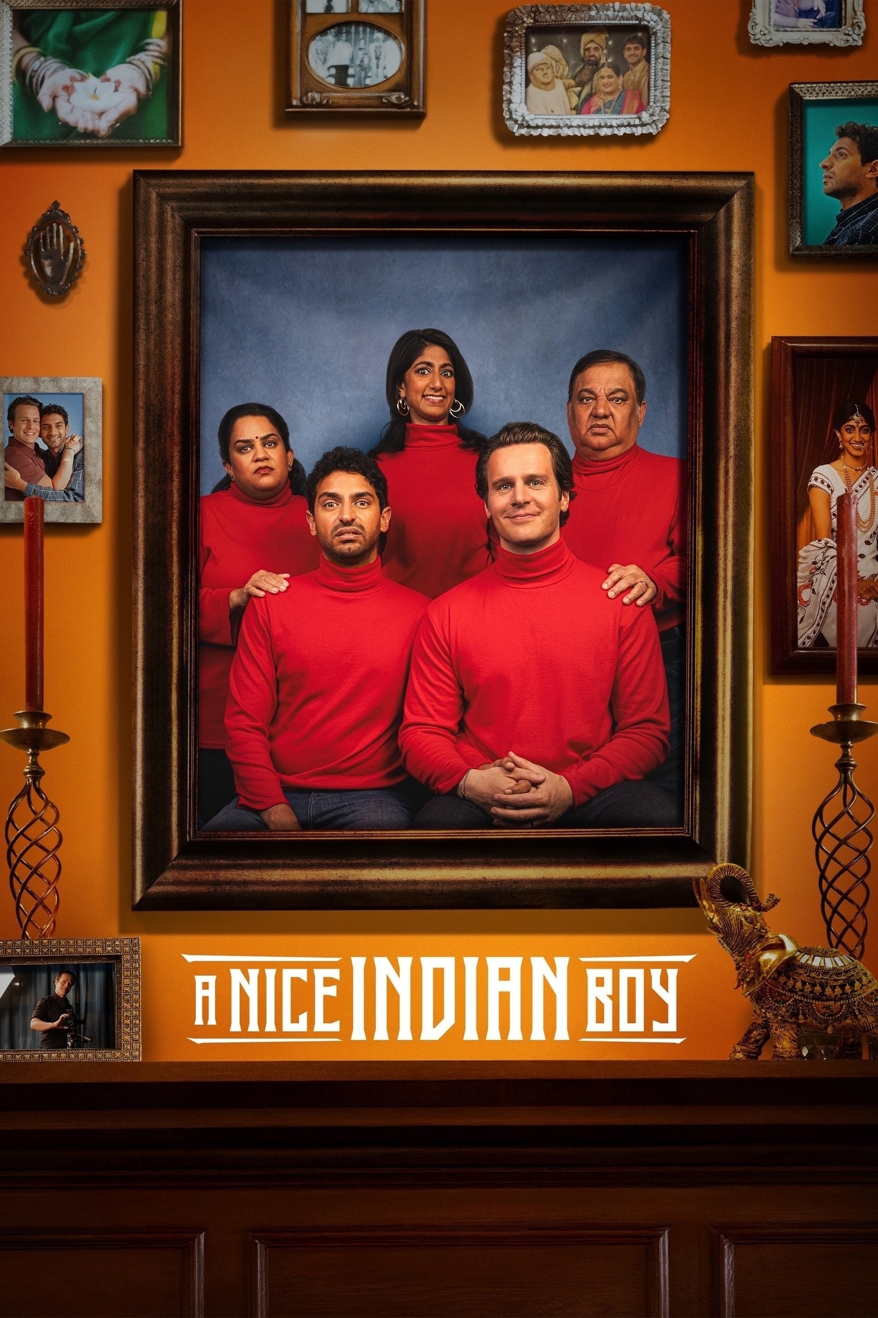 A portrait photograph of five people wearing matching red turtlenecks. Three people are seated in the front row, and two stand behind them. The image is set within an ornate frame, surrounded by other smaller framed photos and decorative items on an orange wall. Below the main photo is the text "A Nice Indian Boy" in bold letters. Two candles flank the main portrait on either side.