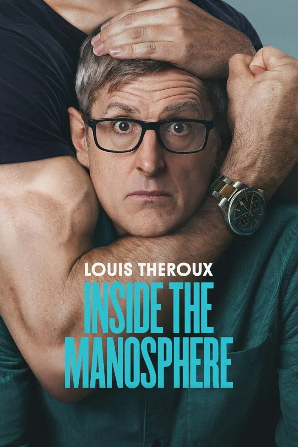 A man with glasses and a surprised expression is encircled by a muscular arm in a headlock. The words "Louis Theroux Inside the Manosphere" are displayed over the image in bold blue and white text.