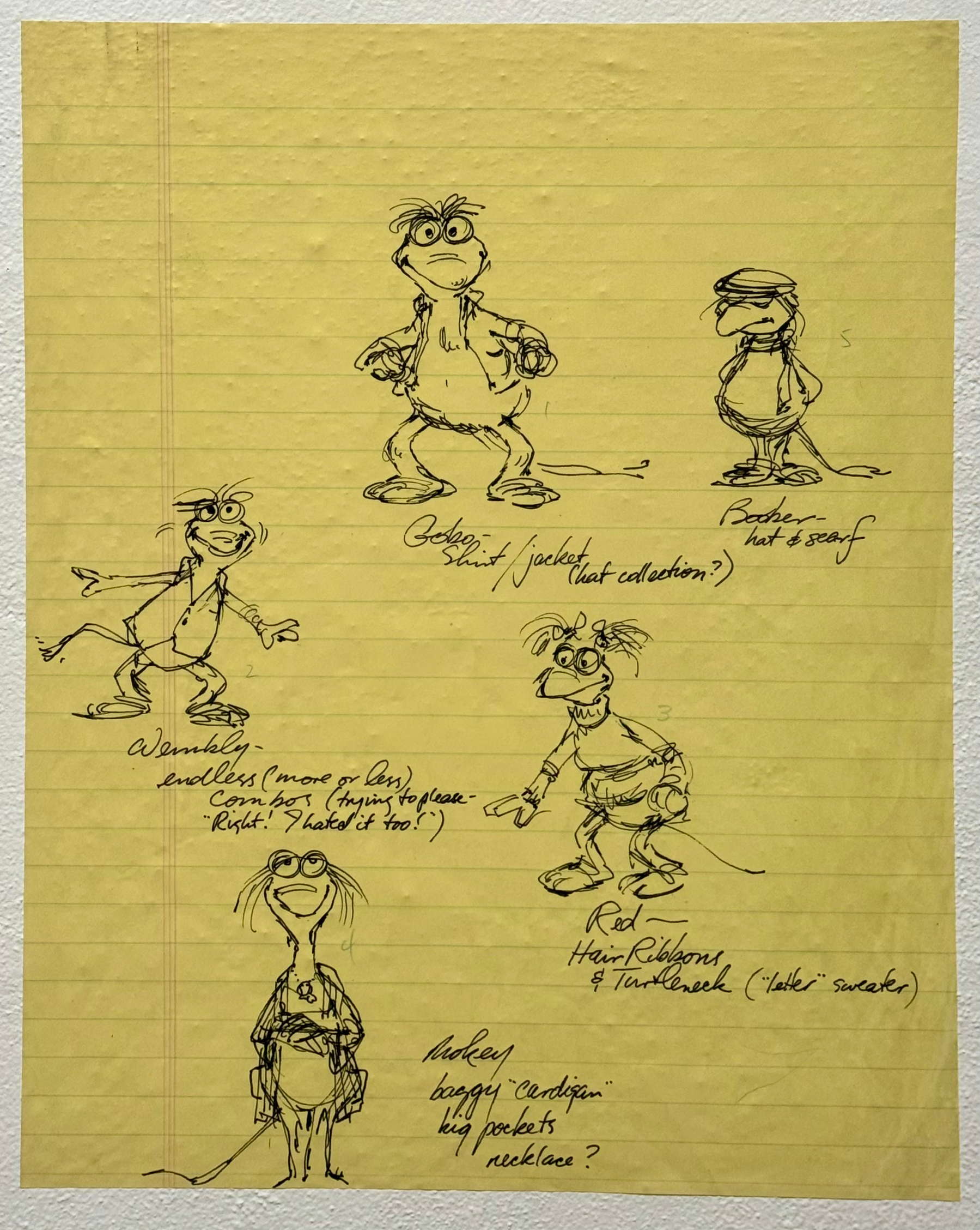A sheet of yellow lined paper with five hand-drawn character sketches of cartoonish, anthropomorphic creatures resembling the Fraggle Rock characters. Each sketch is drawn in black ink with accompanying handwritten notes. The top left drawing shows a creature standing upright with a neutral expression, wearing no clothes; the note reads “Gobo: Shirt/jacket (hat collection?).” To the right, another creature looks down with a hat and scarf, labeled “Boober – hat & scarf.” Below, a lively character is mid-step with arms spread, wearing a long shirt; the note says “Wembley – endless (more or less) combo (trying to please – ‘Right. I hated it too!’).” On the bottom right, a character with pigtails holds an object in one hand, wearing a turtleneck and shorts with a tail sticking out; the note reads “Red – Hair Ribbons & Turtleneck (‘letter’ sweater).” At the bottom left, a taller, thinner character wears a baggy cardigan with big pockets and a possible necklace, labeled “Mokey – baggy ‘cardigan,’ big pockets, necklace?” The paper has faint horizontal lines and a textured wall visible in the background.