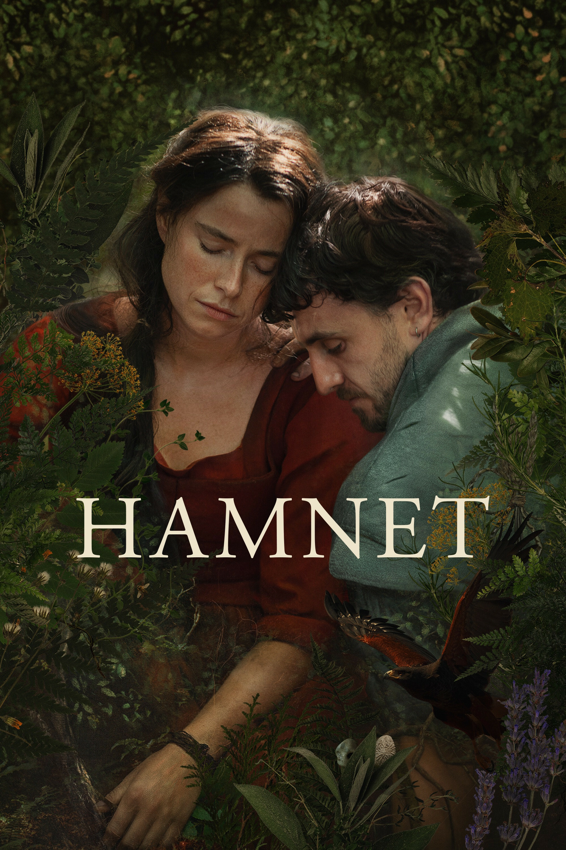 A woman and a man are sitting closely together in a lush, green setting filled with various plants. The woman, wearing a red top, has her eyes closed while the man rests his head on her shoulder. The title "Hamnet" is prominently displayed in large text across the image. A bird is flying near the bottom-right corner among the foliage.