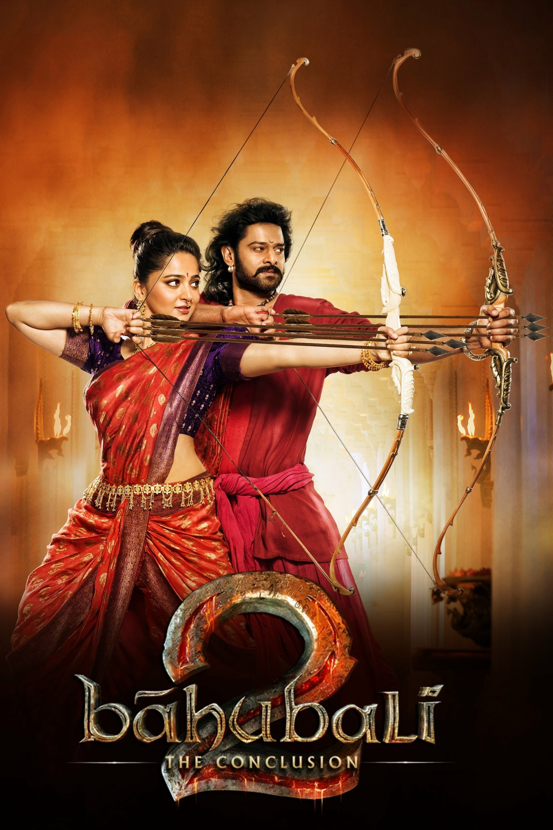 Poster of "Baahubali 2: The Conclusion" featuring two characters standing side by side, both holding bows and ready to shoot arrows. They are dressed in traditional warrior attire, with ornate details. The background is a warm, glowing hue. The movie title is displayed at the bottom with a bold, metallic design.