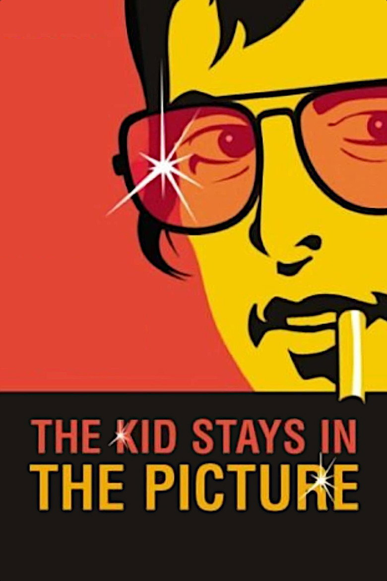 A stylized, pop-art style illustration of a man’s face in bright yellow with black hair, wearing red-tinted aviator sunglasses that reflect a sparkle of light. He is holding a cigarette in his mouth. The background is a solid red-orange color, and the lower third of the image is black. On the black area, the text reads “THE KID STAYS IN THE PICTURE,” with “THE KID STAYS IN” in red and “THE PICTURE” in yellow, with small star-like sparkles on some of the letters.