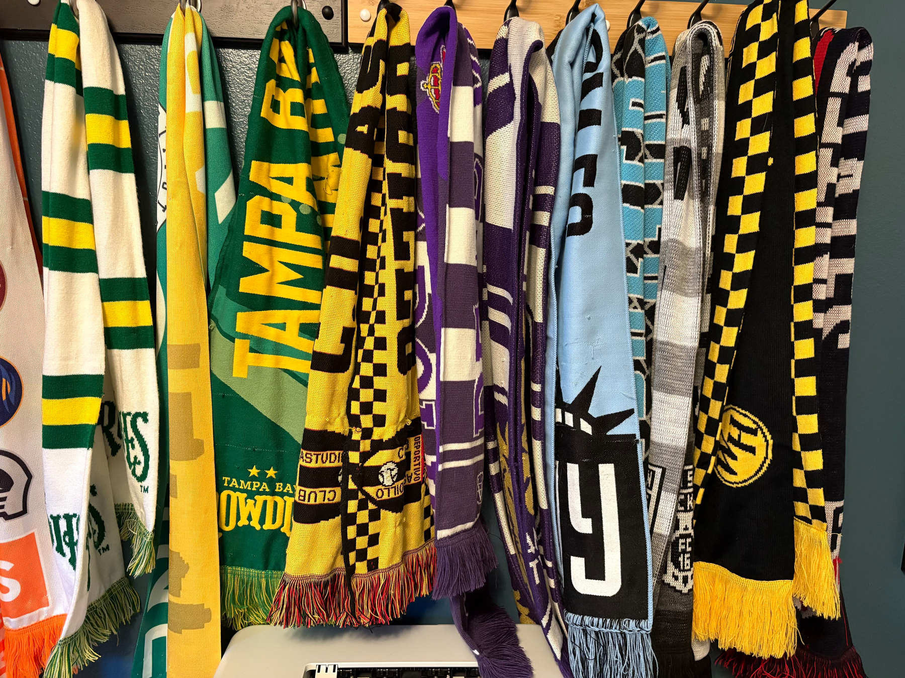 More soccer scarves against a blue wall
