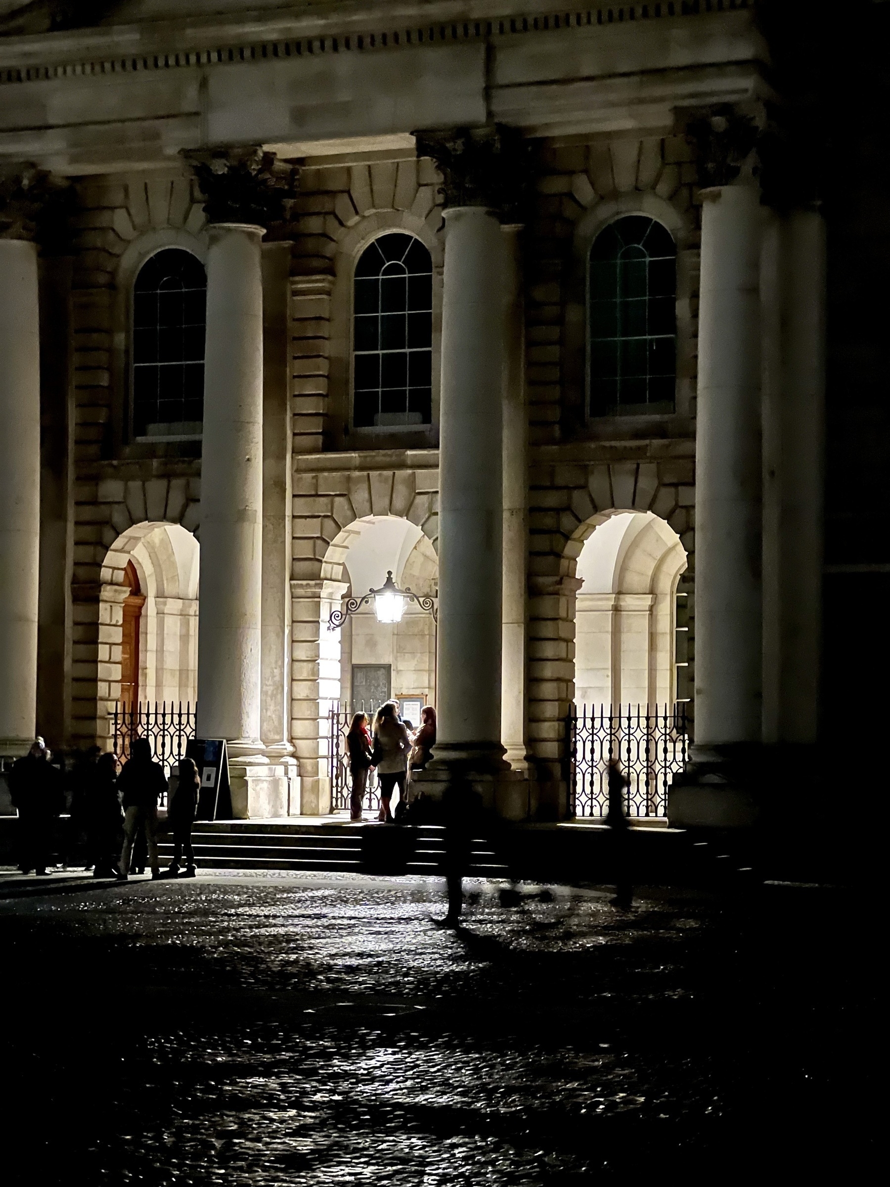 Trinity College Dublin courtyard at night. People chatting. 