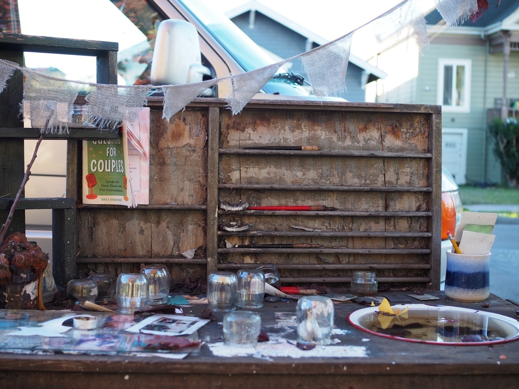 A small wooden shelf in the sidewalk with mementos on it. A kind of neighborhood shrine. 