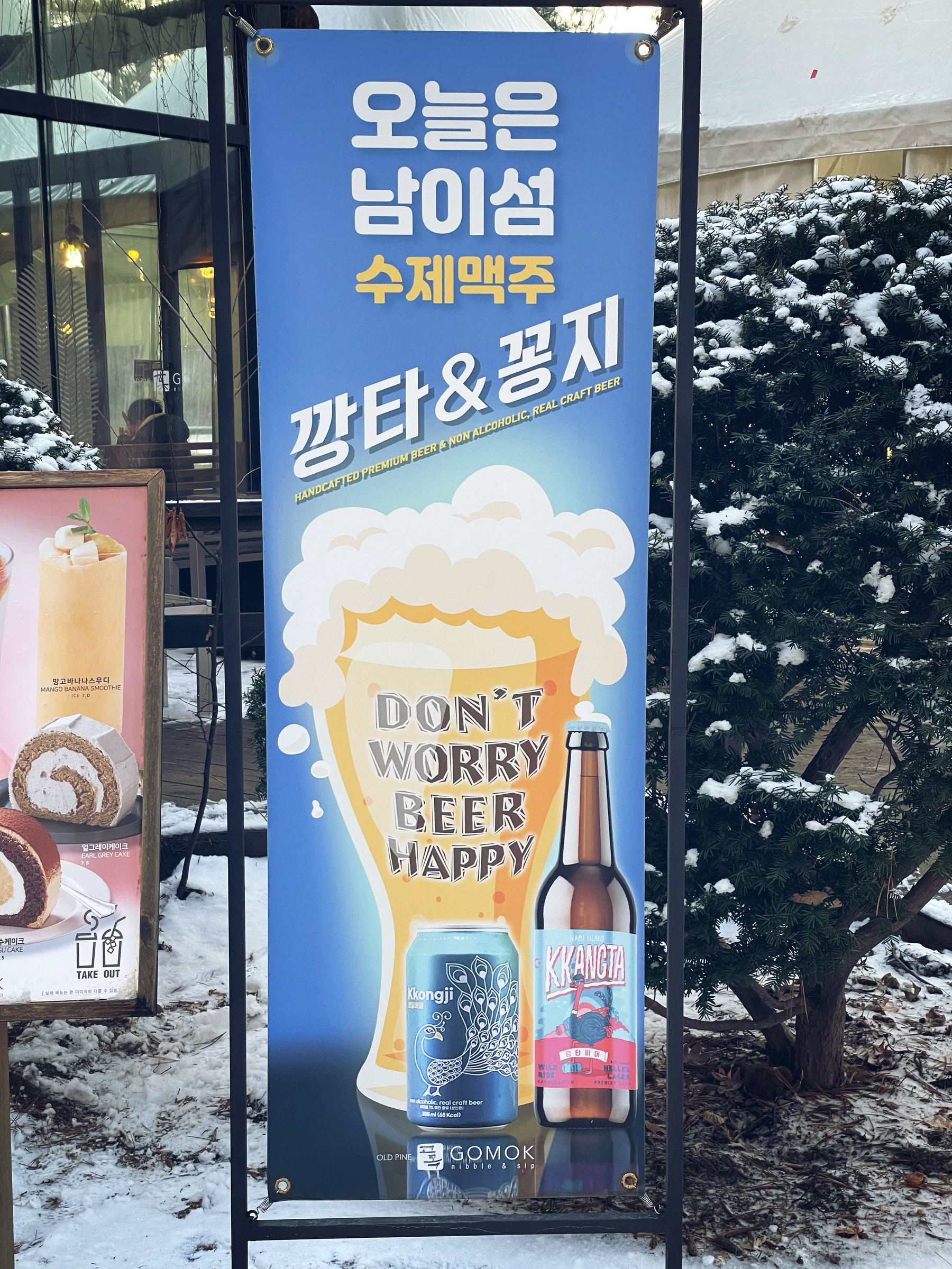 Sign outside a shop on Nami Island with the words, "Don't worry. Beer happy."