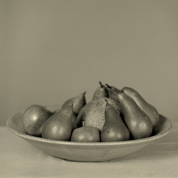 A monochrome photo of some fruit in a bowl.