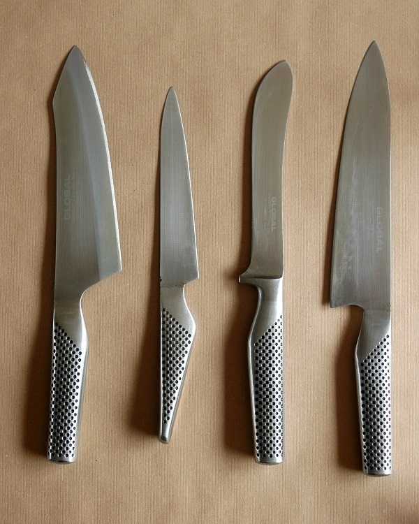 Four 'Global'-brand kitchen knives.