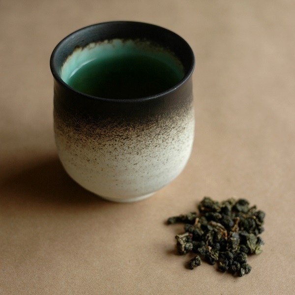 A cup of 'milk oolong' tea, and some of the tea leaves.