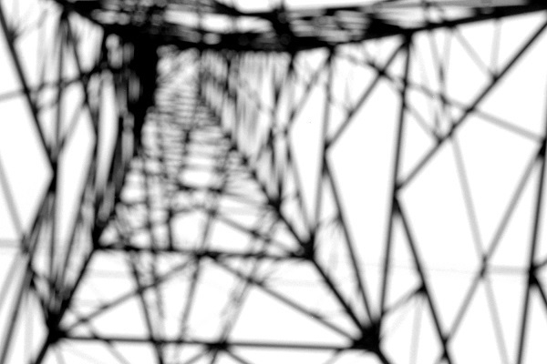 A deliberately out-of-focus monochrome photo of an electricity pylon.