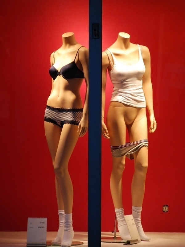 Two mannequins in a shop window.