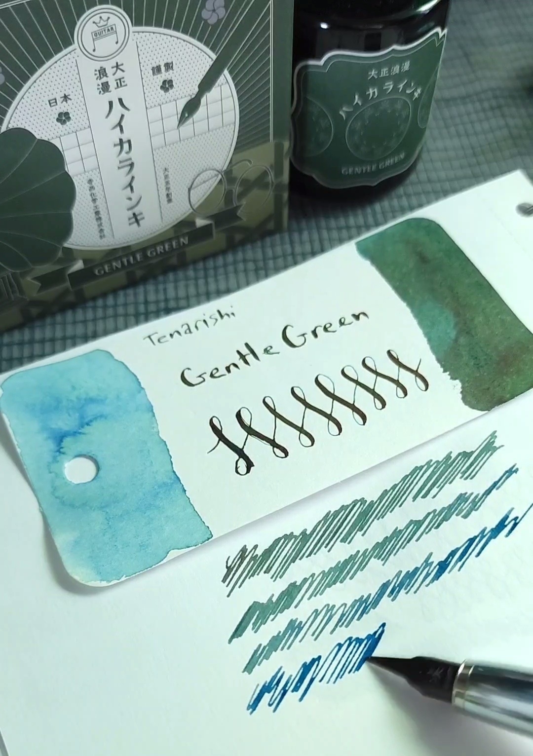 Pen scribbles showing "Gentle Green" fountain pen ink from Teranishi that is bright blue while wet and turns green with red sheen as it dries.