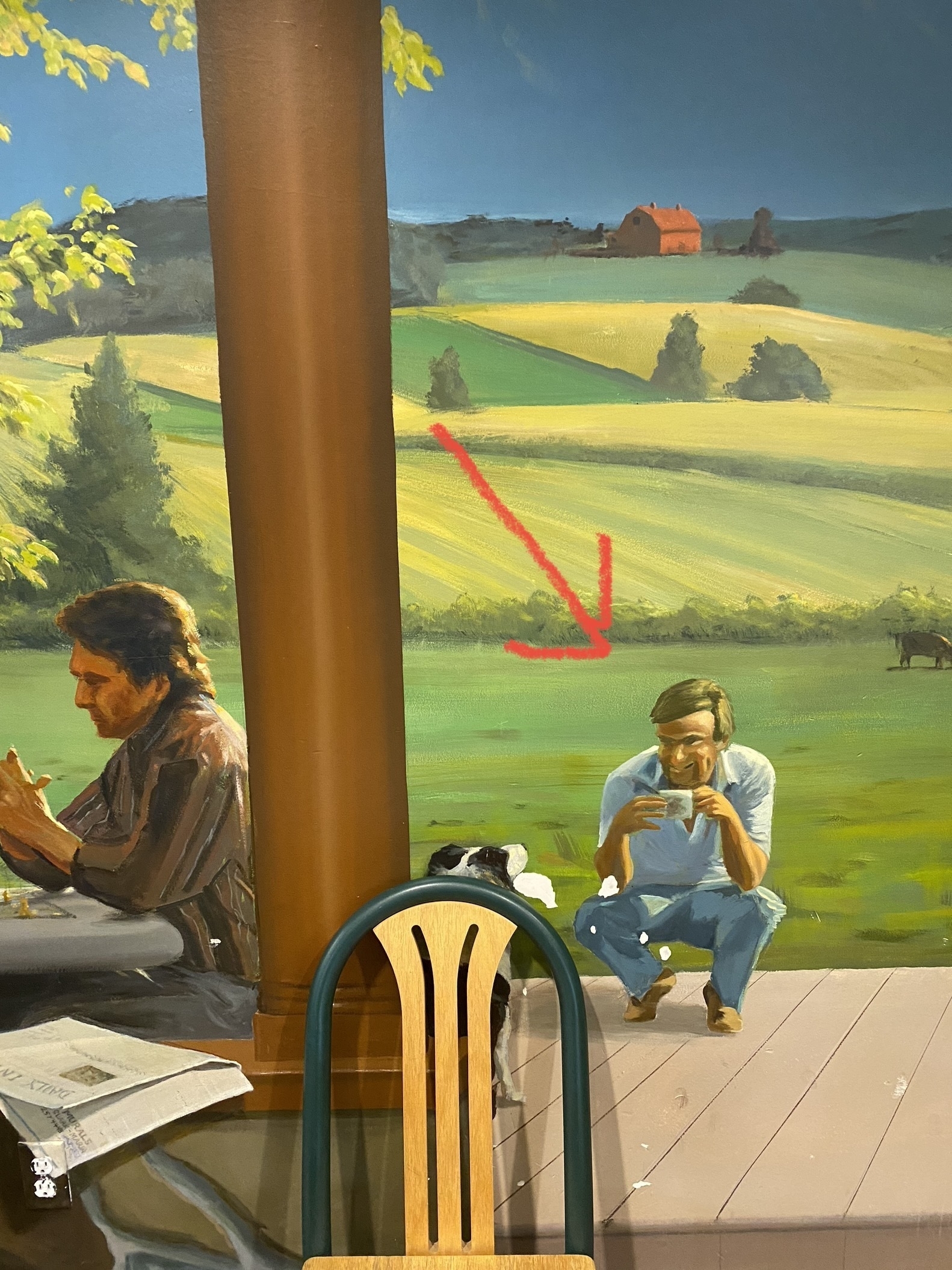 Wall sized airport mural in Kalispell that includes a creepy man kneeling, drinking coffee. His facial expression is frightening. 