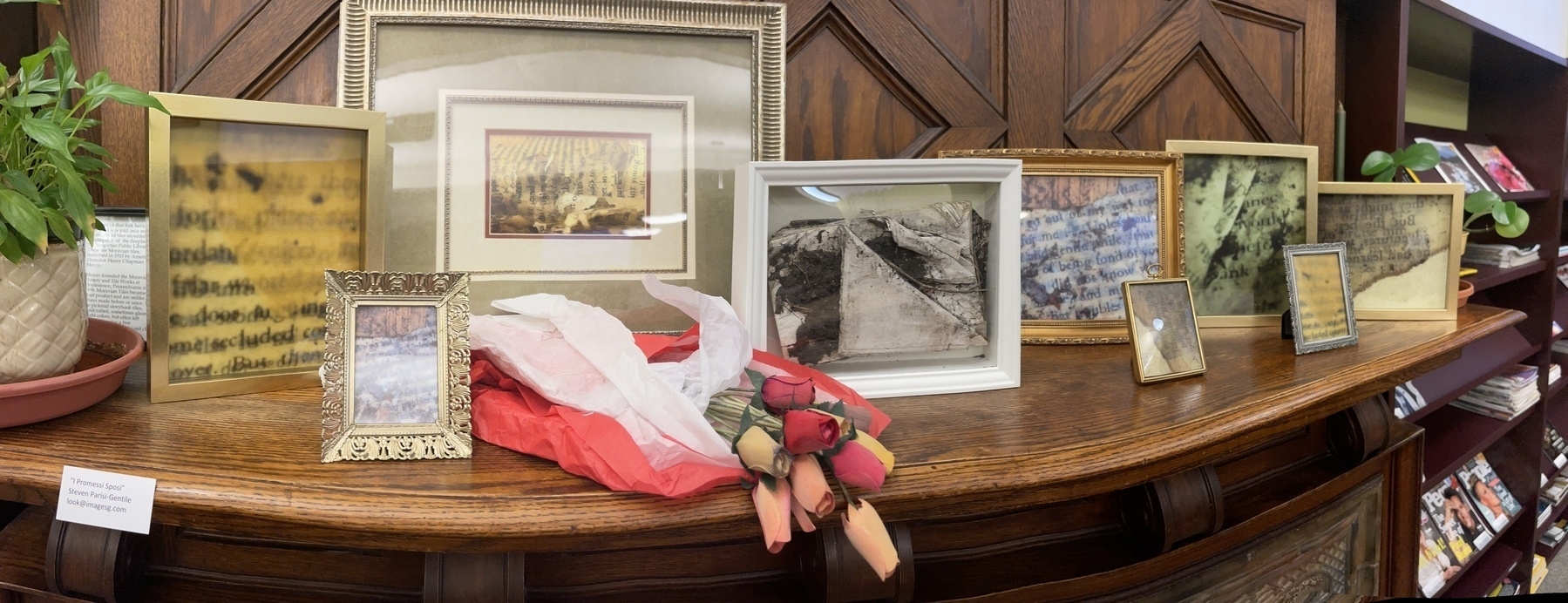 Framed images of a discarded book and roses made paper made from the pages of a discarded book on a fireplace mantle.