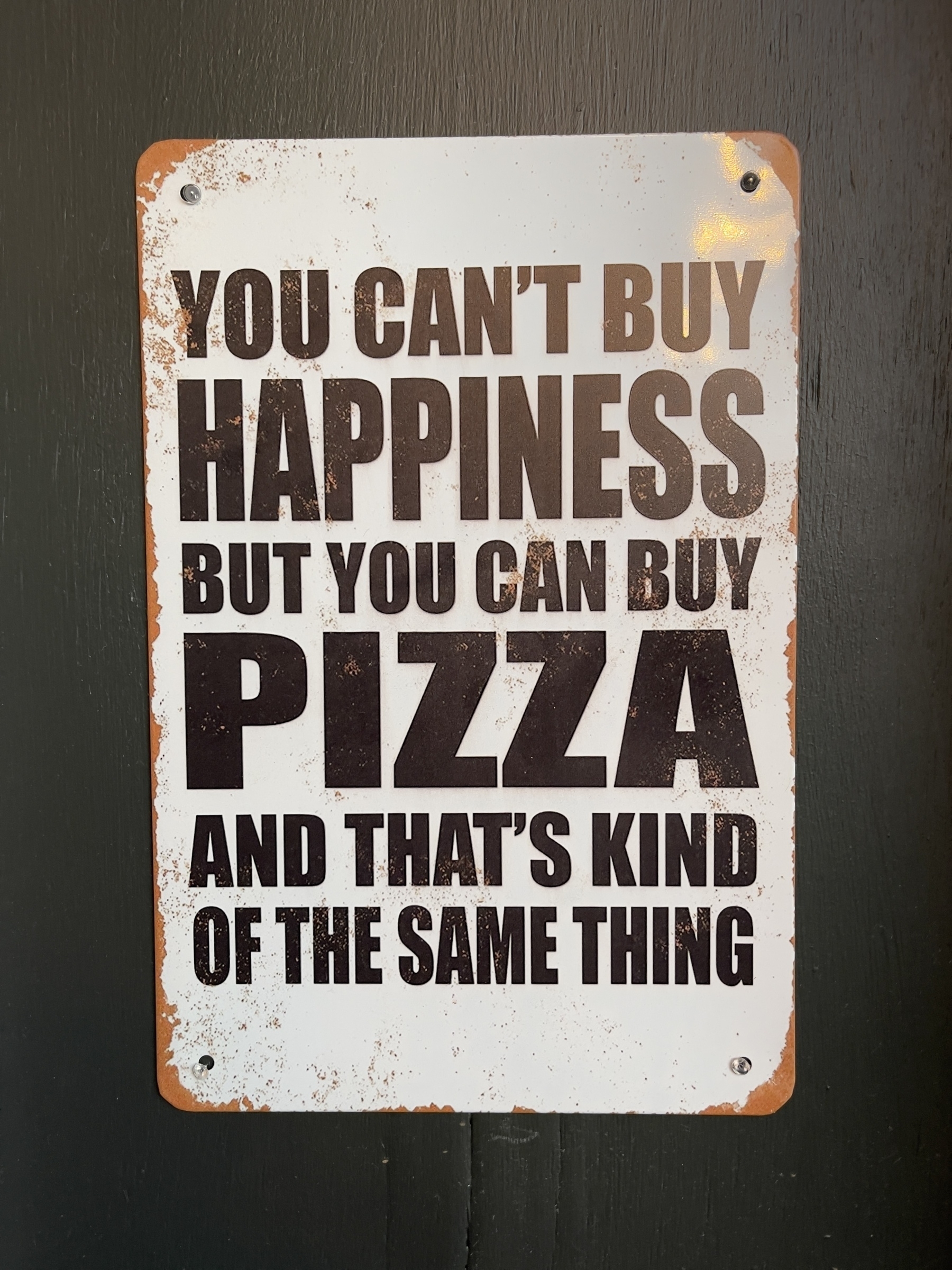Sign saying “you can’t buy happiness but you can buy pizza and that’s kind of the same thing”