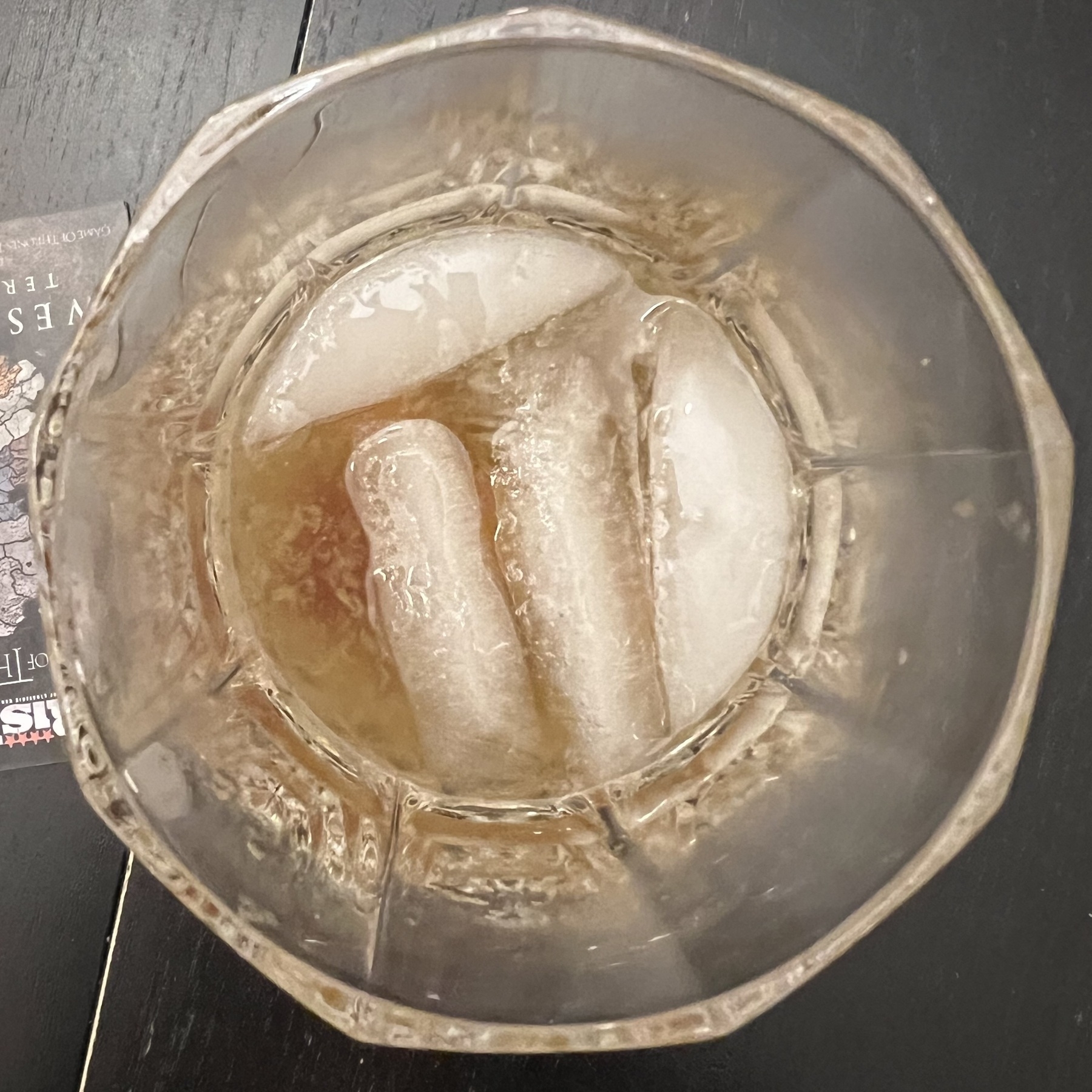 Top down view of a glass with ice and a alcoholic beverage in it. 